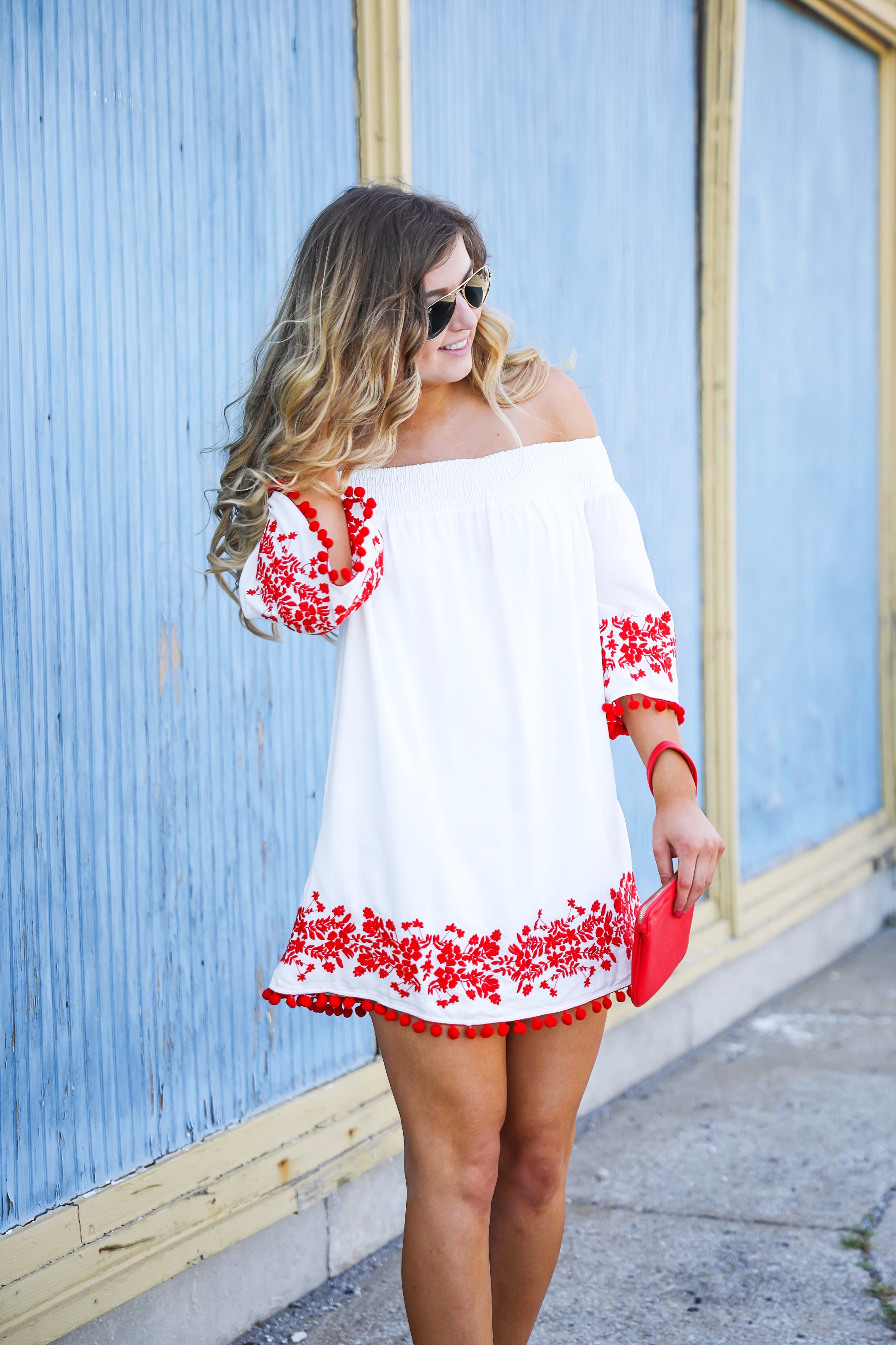Looking for the perfect fourth of july or summer outfit? This red pom pom off the shoulder dress is so cute with it's embroidered hem! I wore this on the fourth of july! Featured on fashion blog daily dose of charm by lauren lindmark
