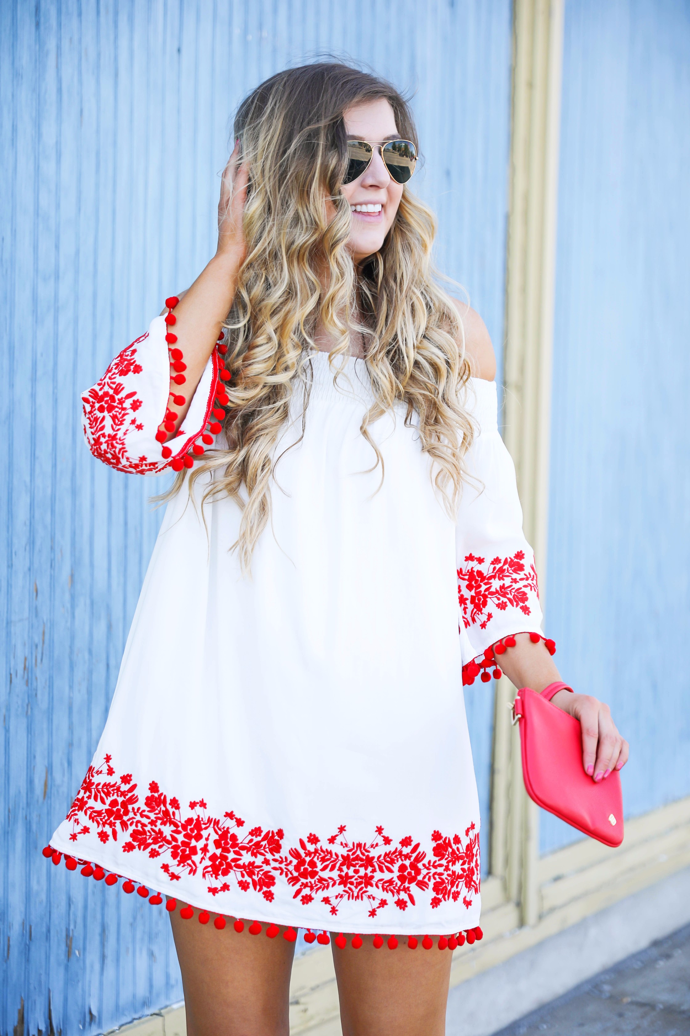 Looking for the perfect fourth of july or summer outfit? This red pom pom off the shoulder dress is so cute with it's embroidered hem! I wore this on the fourth of july! Featured on fashion blog daily dose of charm by lauren lindmark