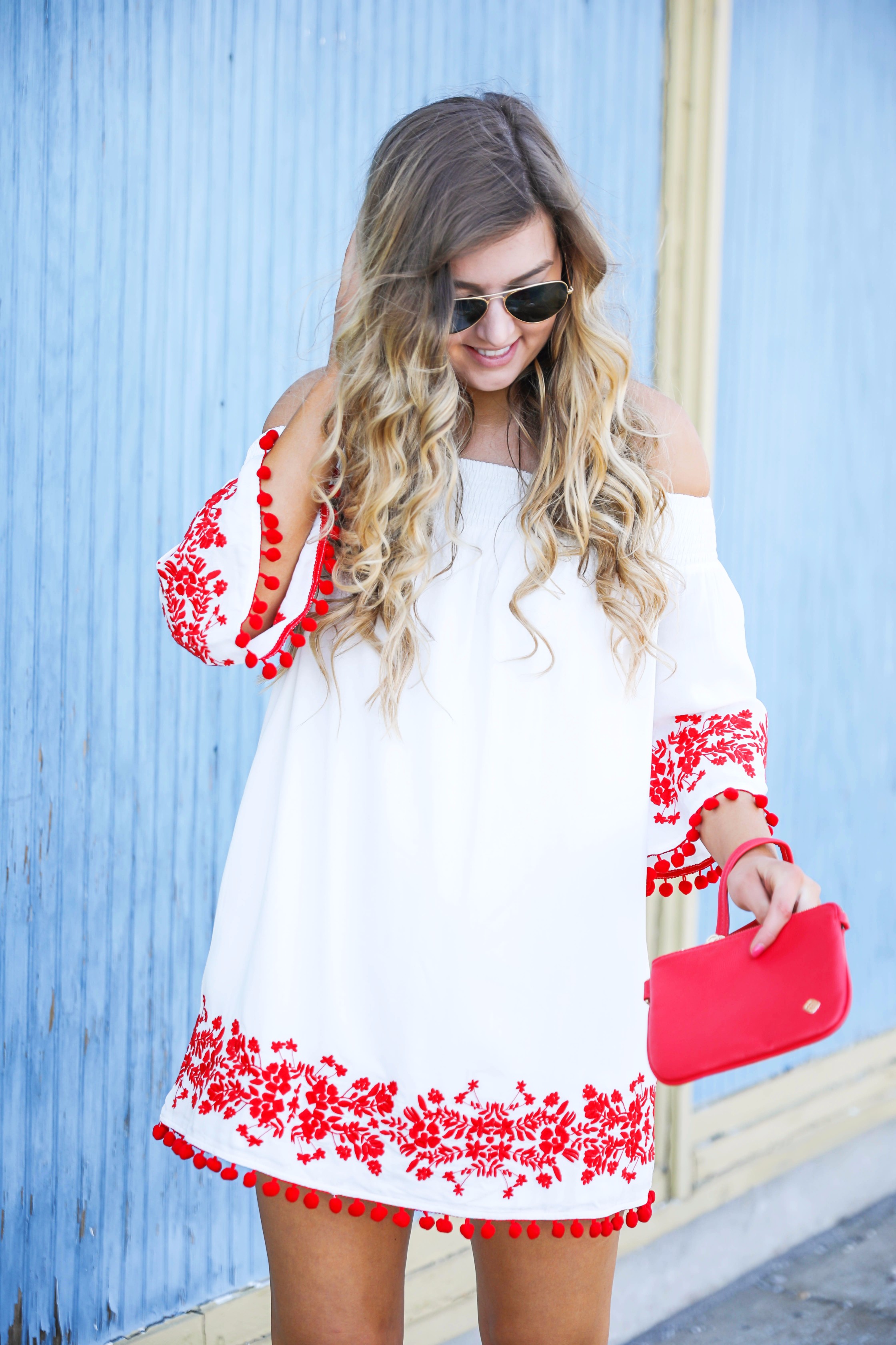 Looking for the perfect fourth of july or summer outfit? This red pom pom off the shoulder dress is so cute with it's embroidered hem! I wore this on the fourth of july! Featured on fashion blog daily dose of charm by lauren lindmark