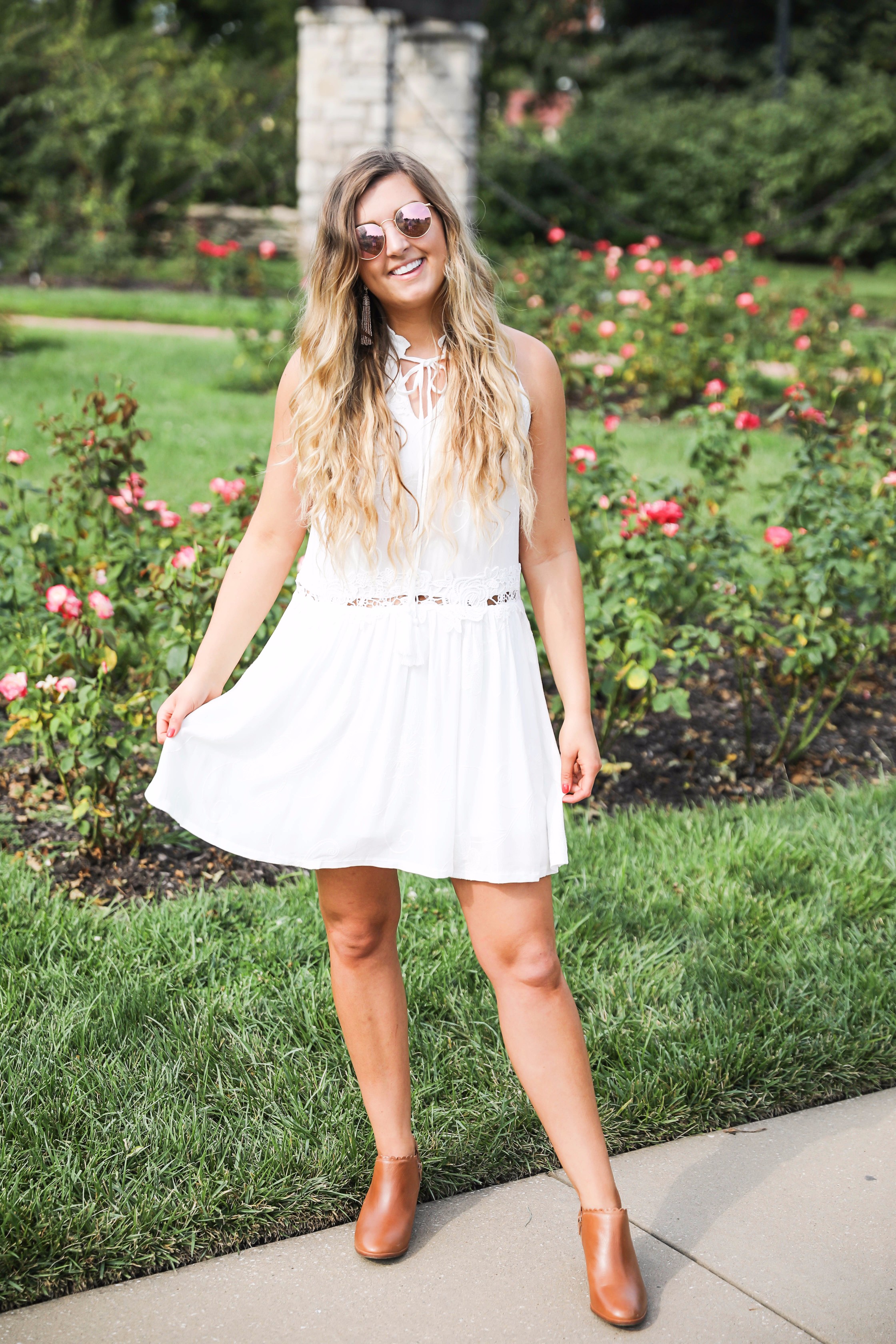 Flowy white dress surrounded by flowers! I love this dress, it's so fun and flowy and it looks so good with booties to transition into fall! Find details on fashion blogger daily dose of charm by lauren lindmark