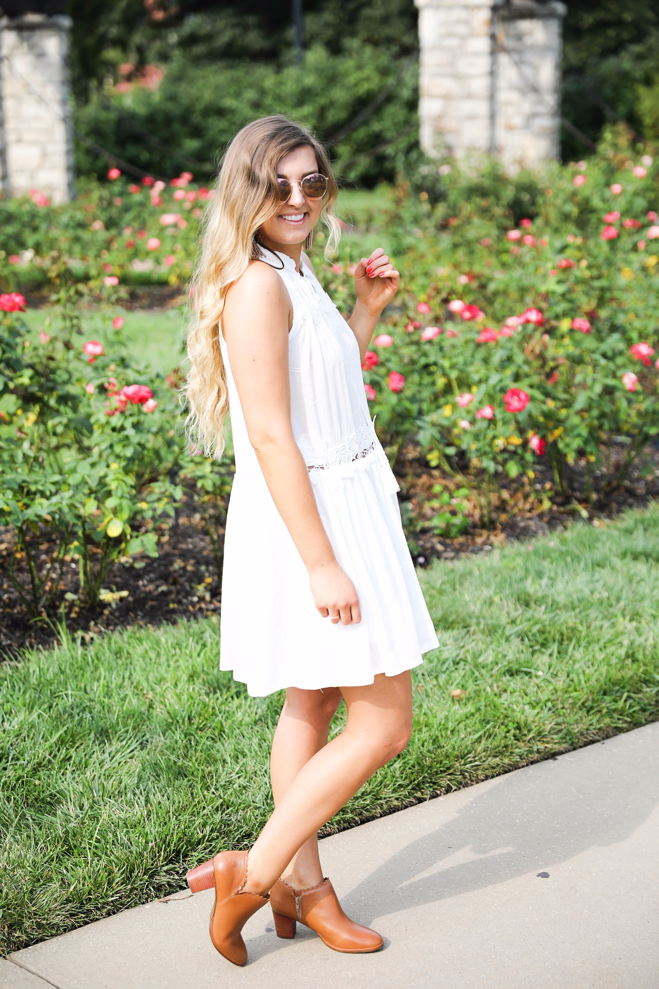 Flowy white dress surrounded by flowers! I love this dress, it's so fun and flowy and it looks so good with booties to transition into fall! Find details on fashion blogger daily dose of charm by lauren lindmark