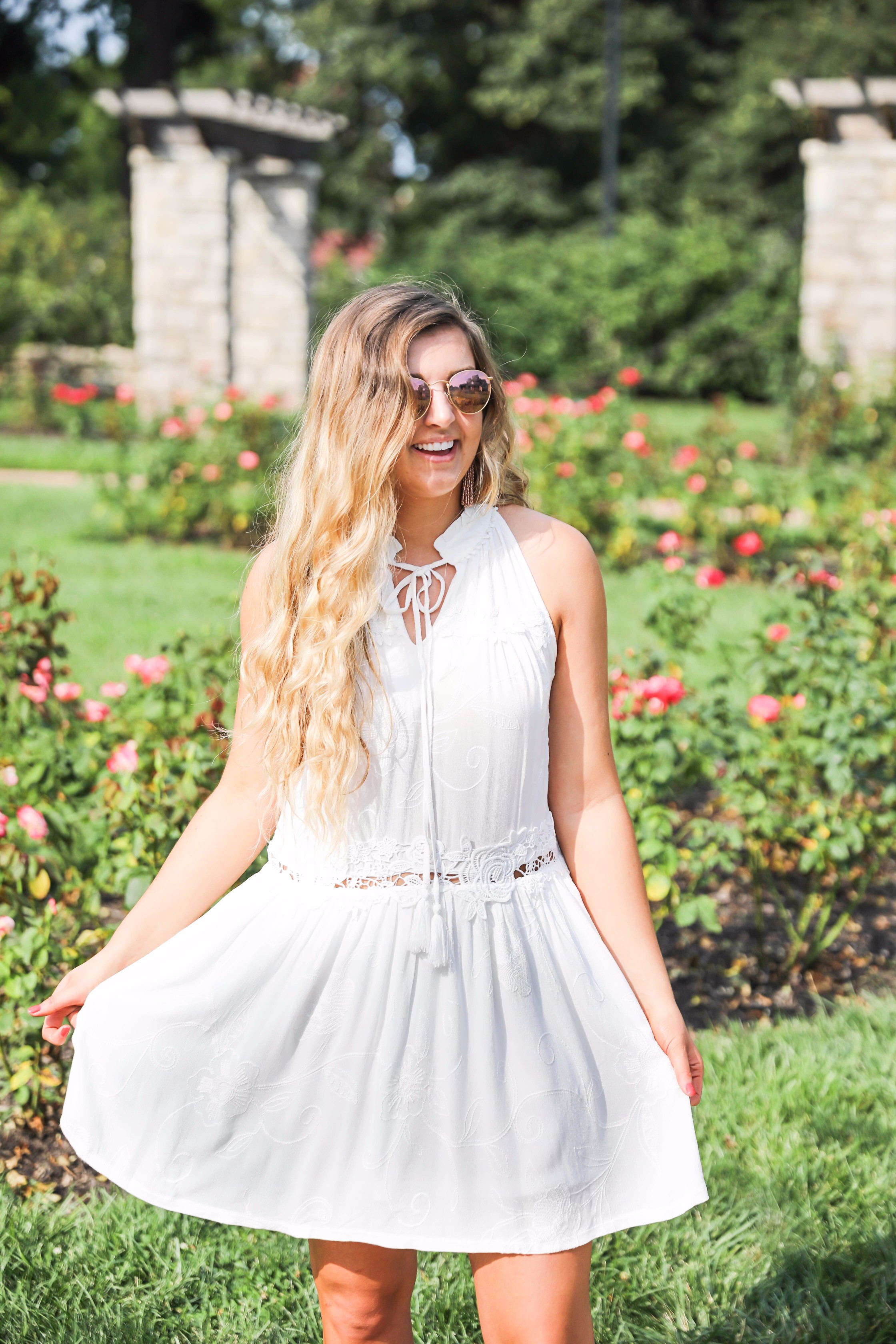 Flowy white dress surrounded by flowers! I love this dress, it's so fun and flowy and it looks so good with booties to transition into fall! Find details on fashion blogger daily dose of charm by lauren lindmark