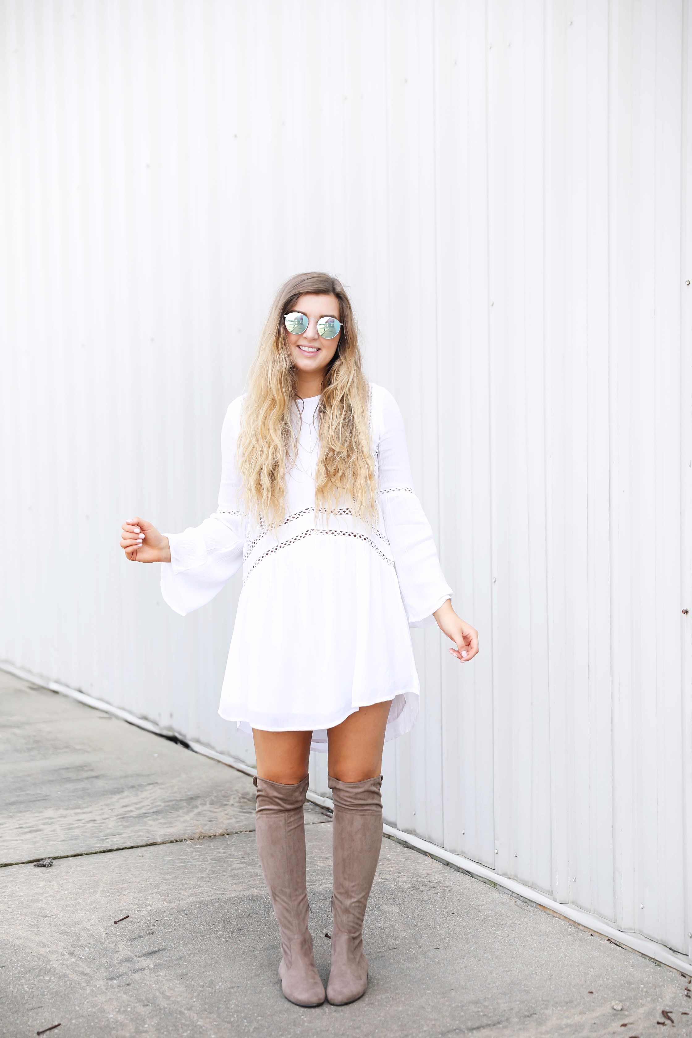 White boho cutout dress with over the knee light brown suede boots! Paired with light blue circle sunglasses. Such a cute dress for summer going into fall! Find the details on fashion blog daily dose of charm by lauren lindmark