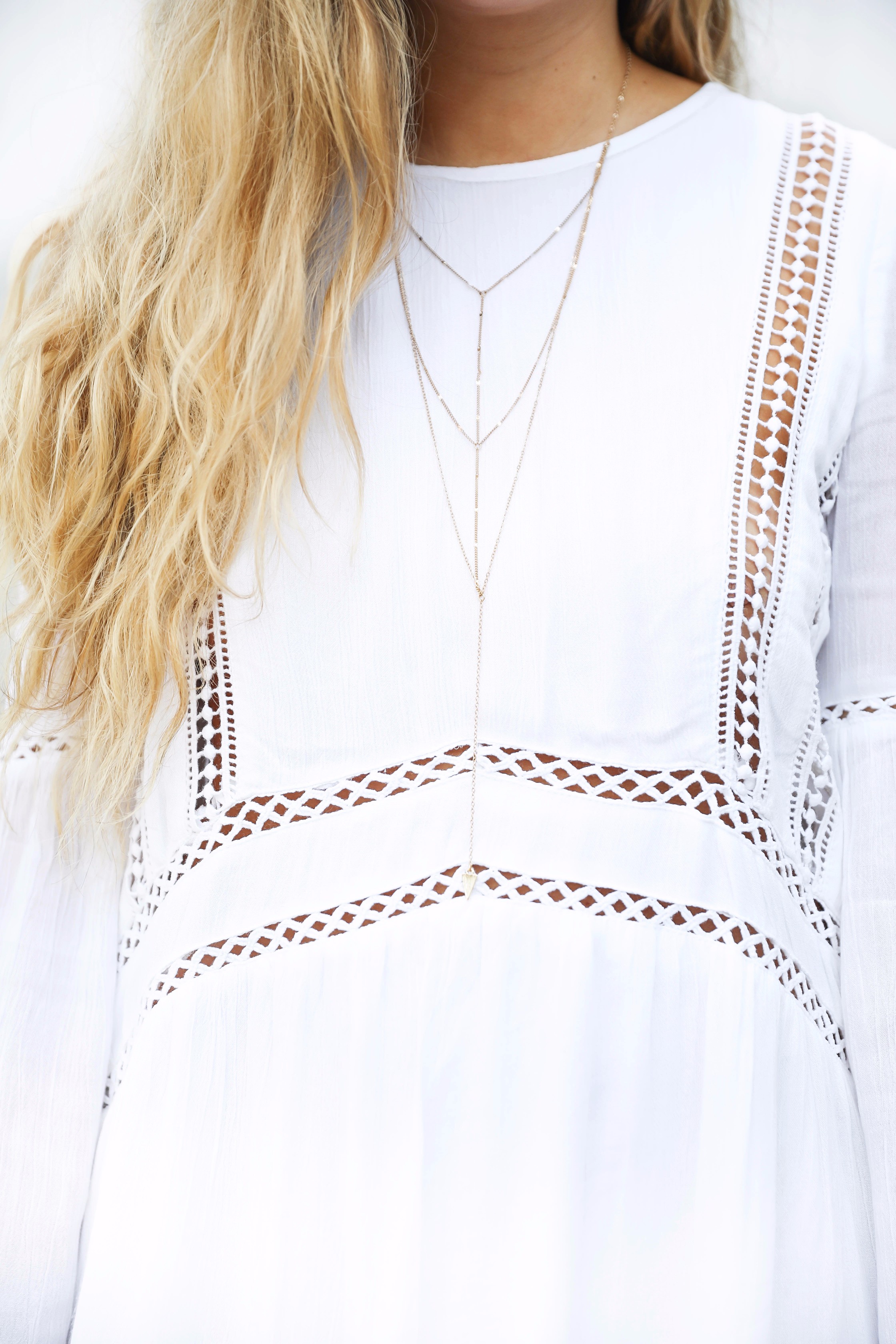 White boho cutout dress with over the knee light brown suede boots! Paired with light blue circle sunglasses. Such a cute dress for summer going into fall! Find the details on fashion blog daily dose of charm by lauren lindmark