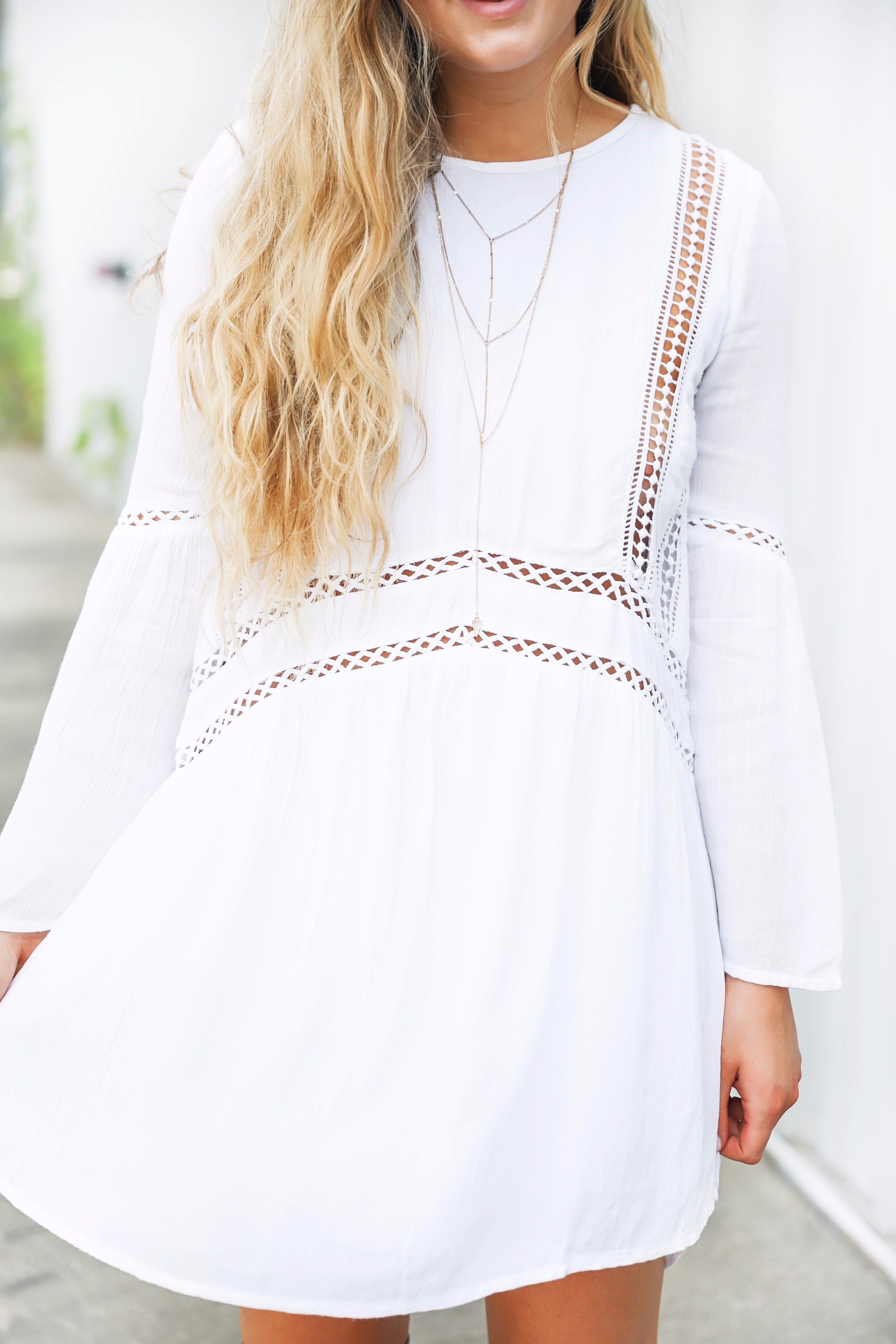 White boho cutout dress with over the knee light brown suede boots! Paired with light blue circle sunglasses. Such a cute dress for summer going into fall! Find the details on fashion blog daily dose of charm by lauren lindmark