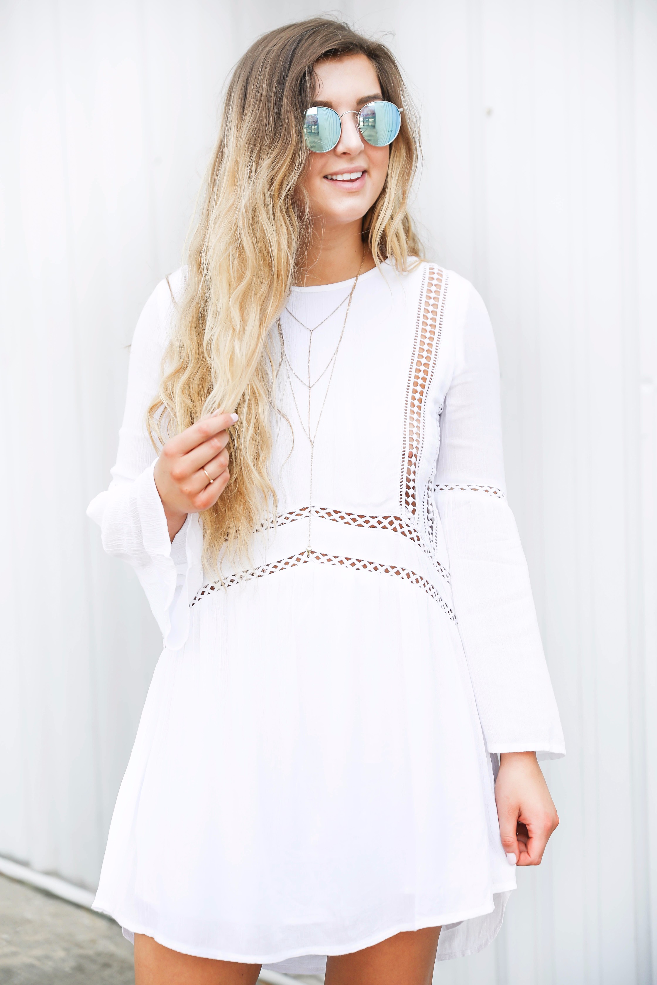 White boho cutout dress with over the knee light brown suede boots! Paired with light blue circle sunglasses. Such a cute dress for summer going into fall! Find the details on fashion blog daily dose of charm by lauren lindmark