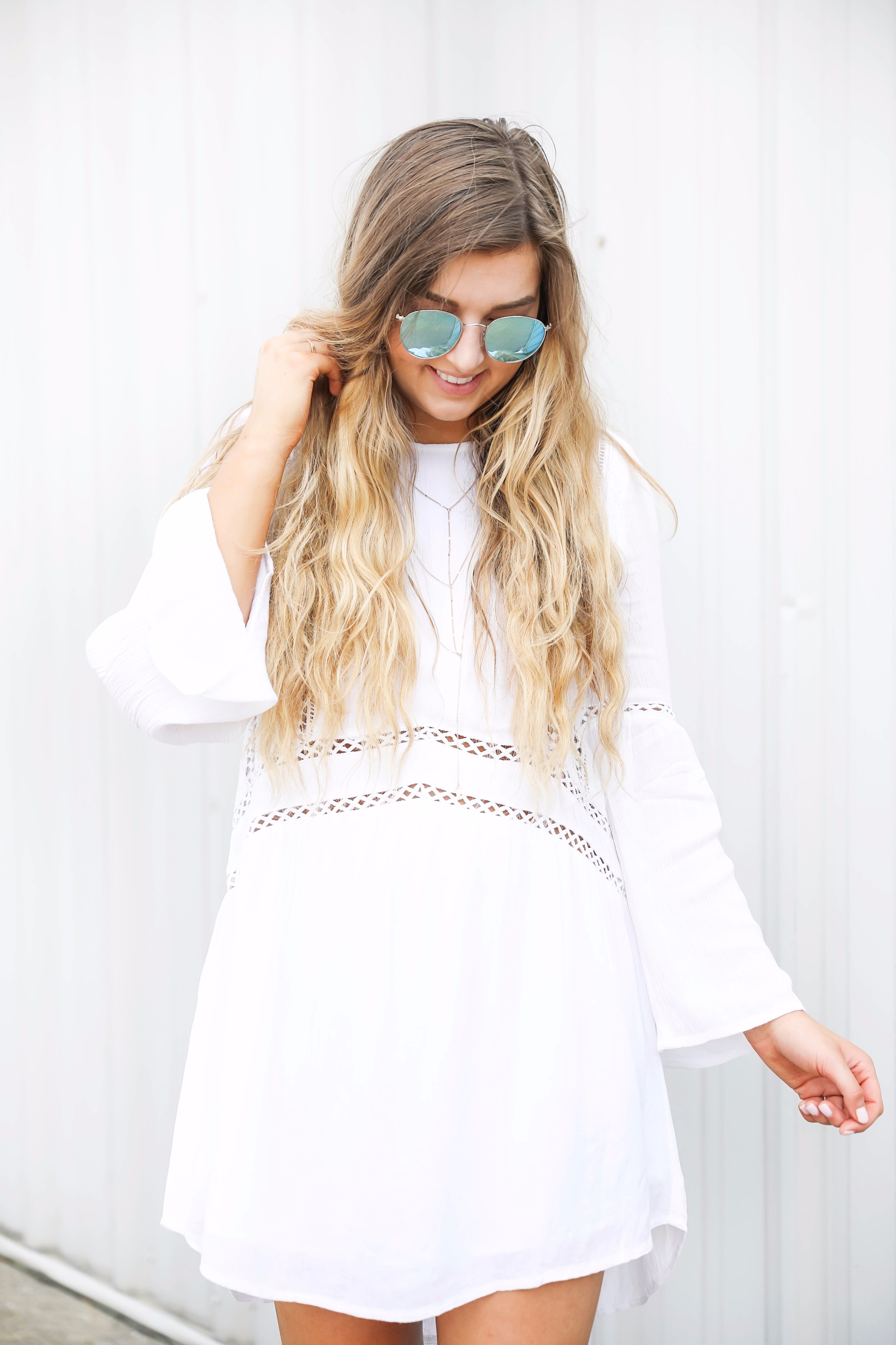 White boho cutout dress with over the knee light brown suede boots! Paired with light blue circle sunglasses. Such a cute dress for summer going into fall! Find the details on fashion blog daily dose of charm by lauren lindmark