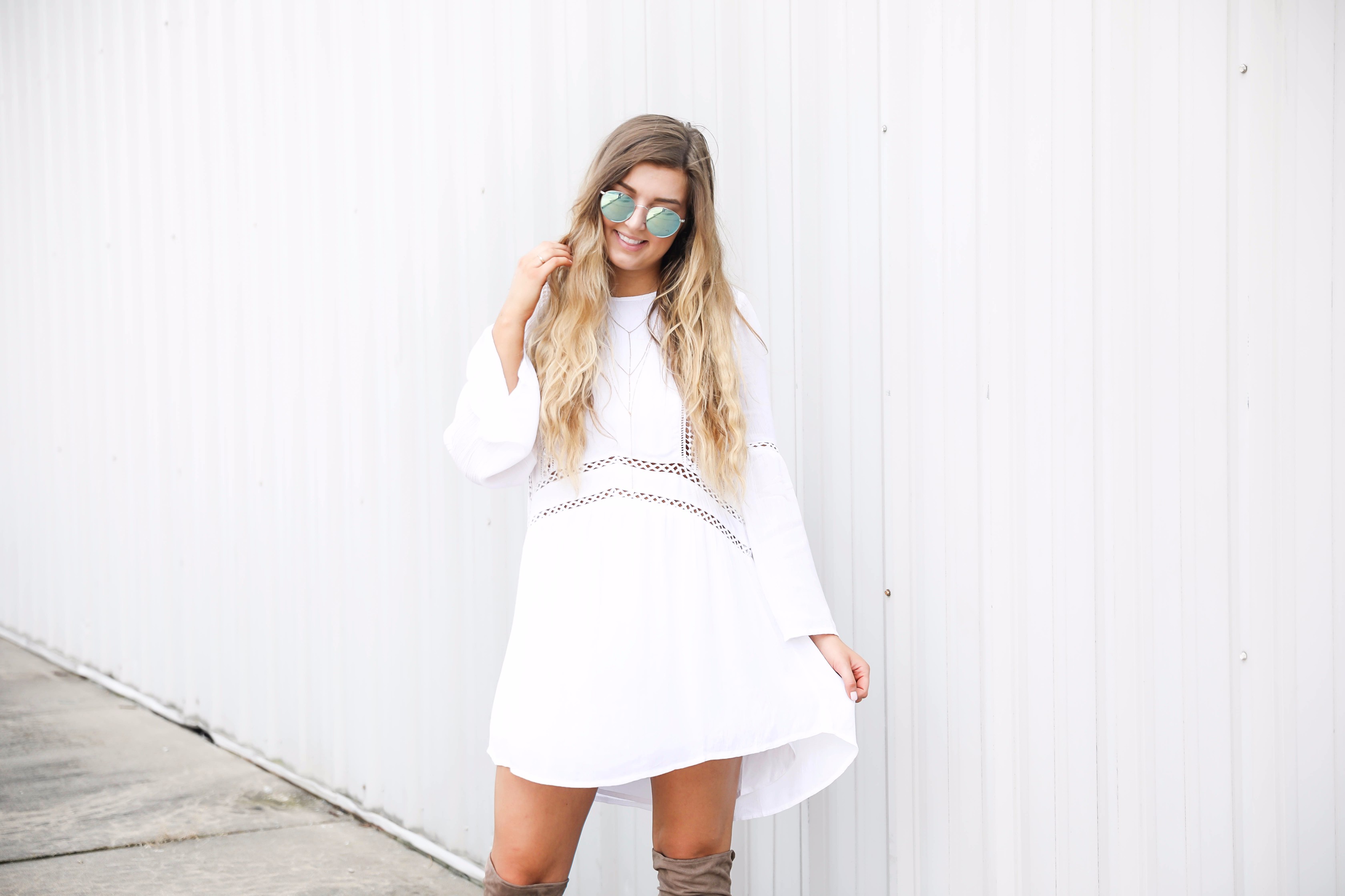 White boho cutout dress with over the knee light brown suede boots! Paired with light blue circle sunglasses. Such a cute dress for summer going into fall! Find the details on fashion blog daily dose of charm by lauren lindmark