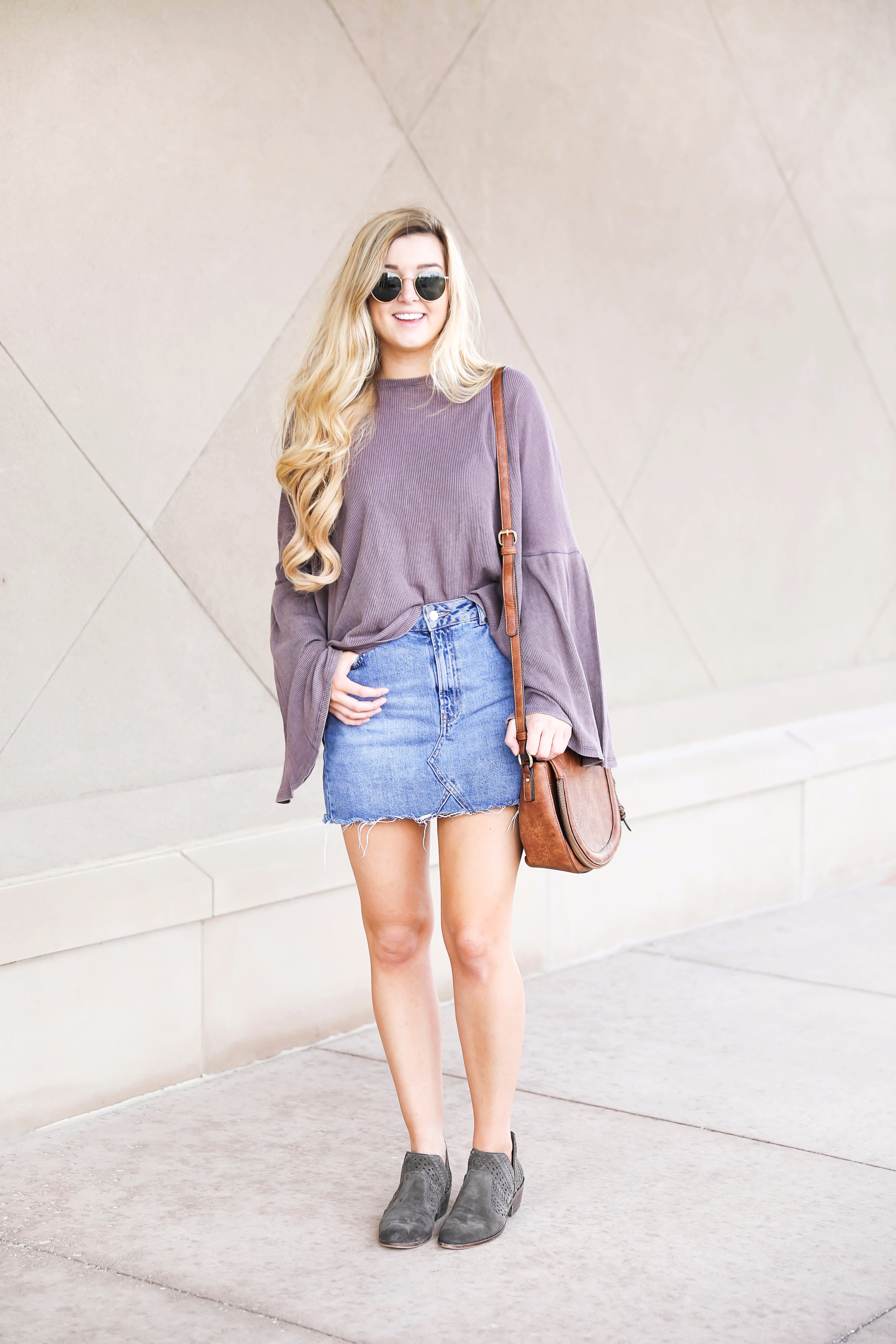 Purple bell sleeve top with jean skirt and saddle bag! Paired with cutout booties! Find the details on fashion blog daily dose of charm by lauren lindmark