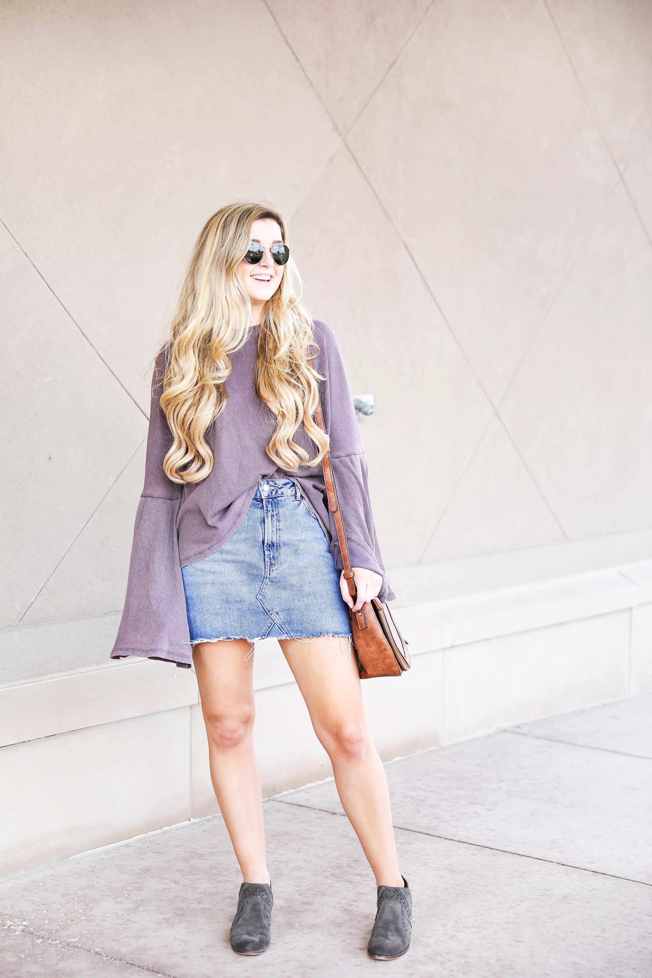 Purple bell sleeve top with jean skirt and saddle bag! Paired with cutout booties! Find the details on fashion blog daily dose of charm by lauren lindmark