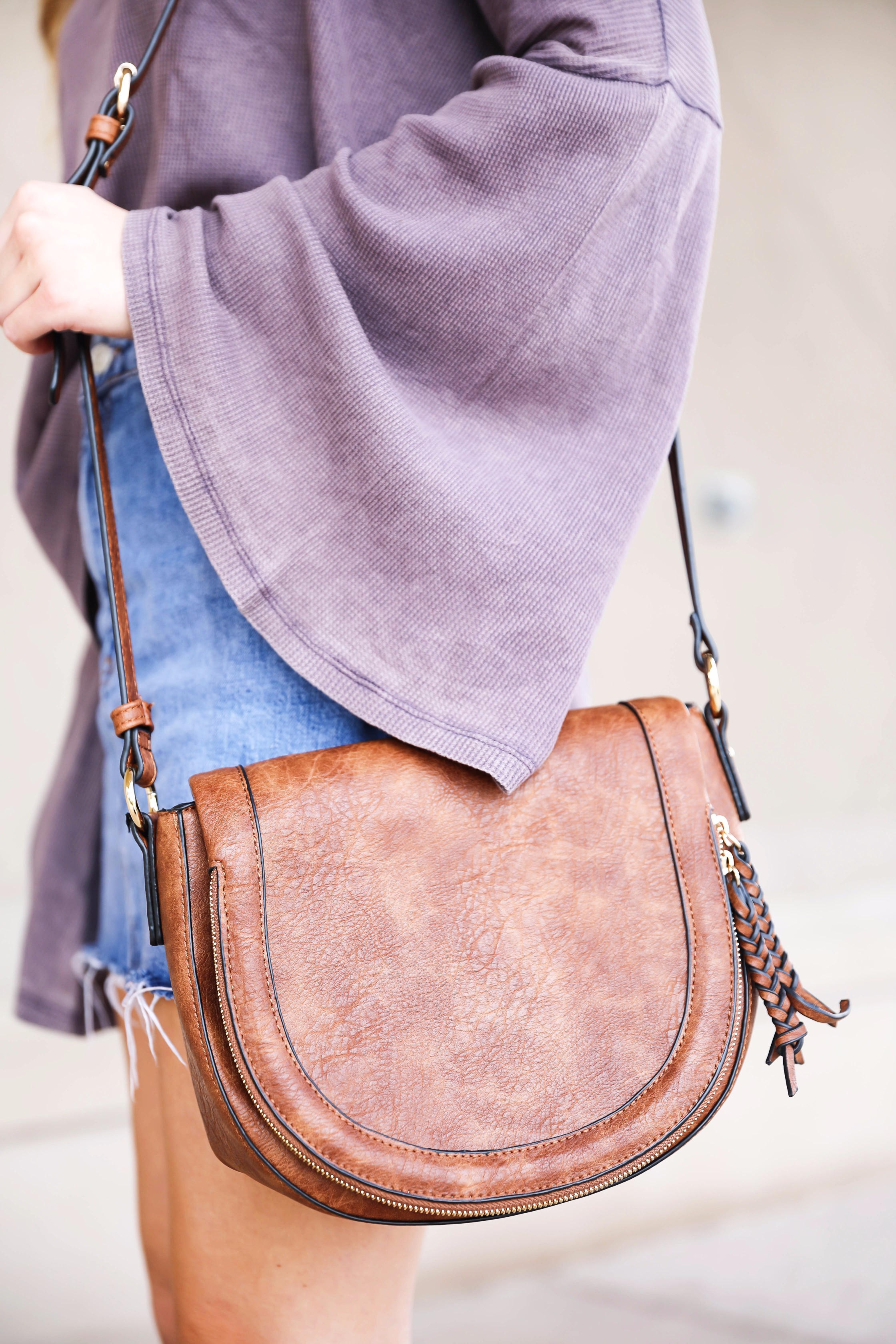 Purple bell sleeve top with jean skirt and saddle bag! Paired with cutout booties! Find the details on fashion blog daily dose of charm by lauren lindmark