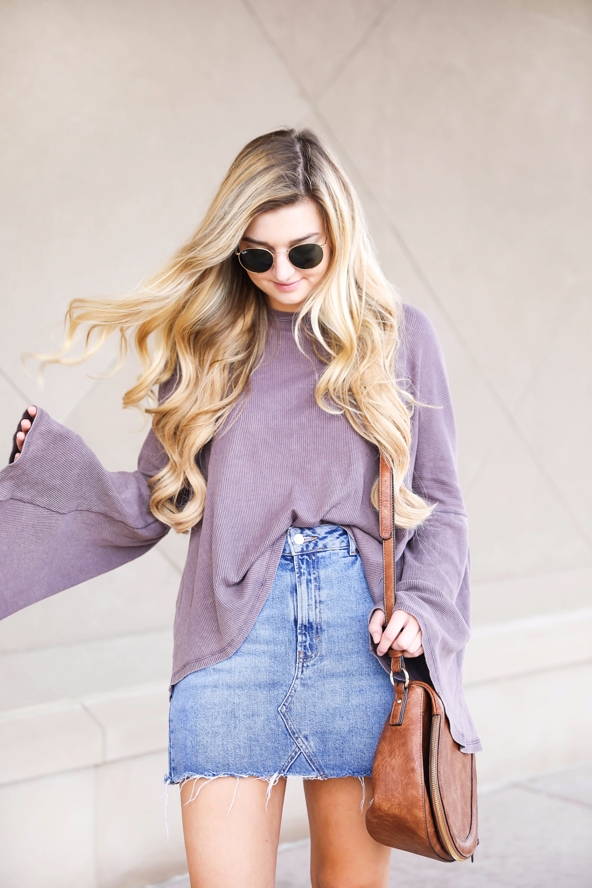 Purple bell sleeve top with jean skirt and saddle bag! Paired with cutout booties! Find the details on fashion blog daily dose of charm by lauren lindmark