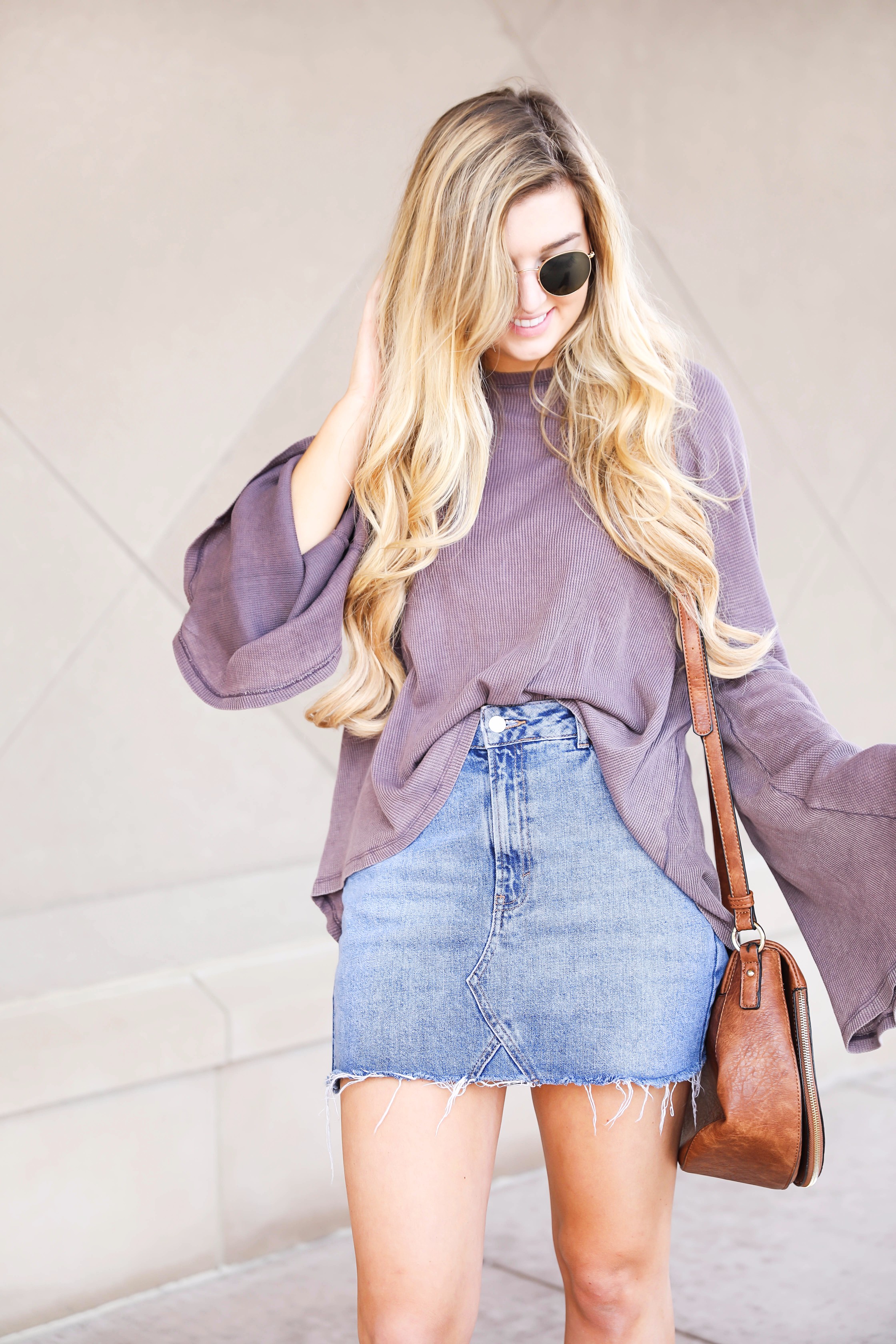 Purple bell sleeve top with jean skirt and saddle bag! Paired with cutout booties! Find the details on fashion blog daily dose of charm by lauren lindmark