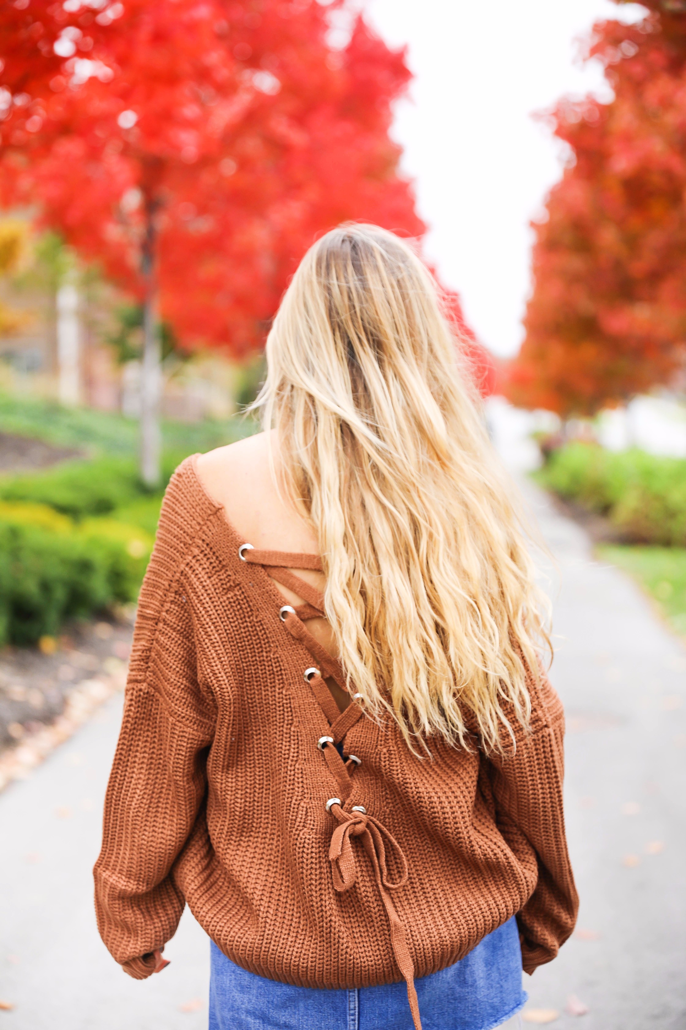 Burnt orange sweater that is crisscrossed tied in the back! Perfect for fall paired with jeanskirt and floppy felt hat. Fall and thanksgiving outfit ideas! Details on fashion blog daily dose of charm by lauren lindmark