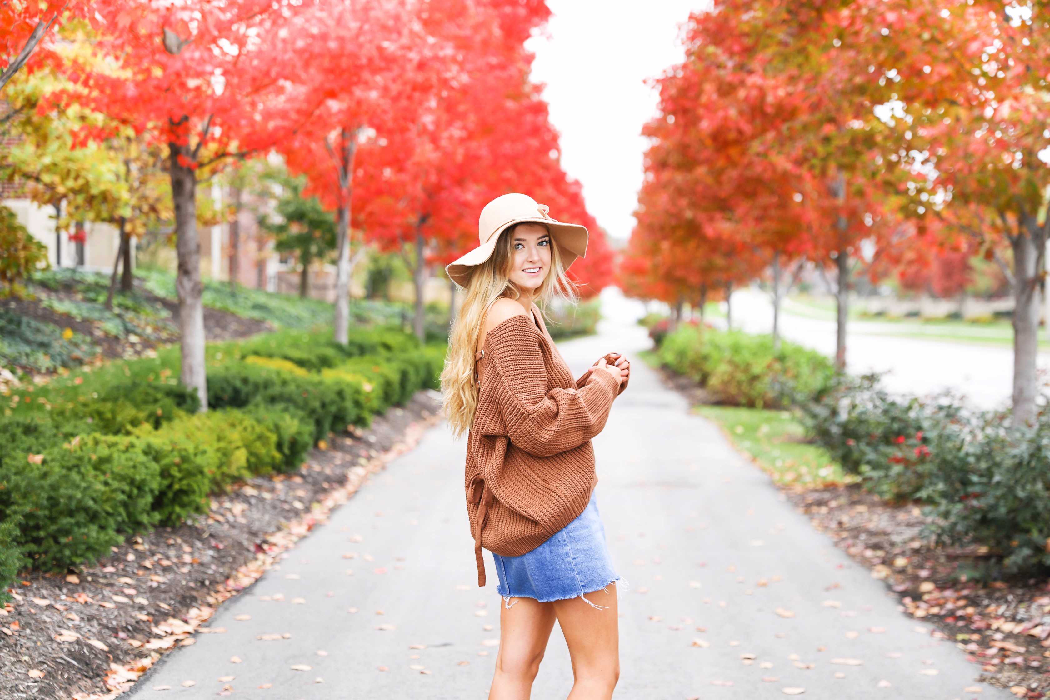 Burnt orange sweater that is crisscrossed tied in the back! Perfect for fall paired with jeanskirt and floppy felt hat. Fall and thanksgiving outfit ideas! Details on fashion blog daily dose of charm by lauren lindmark