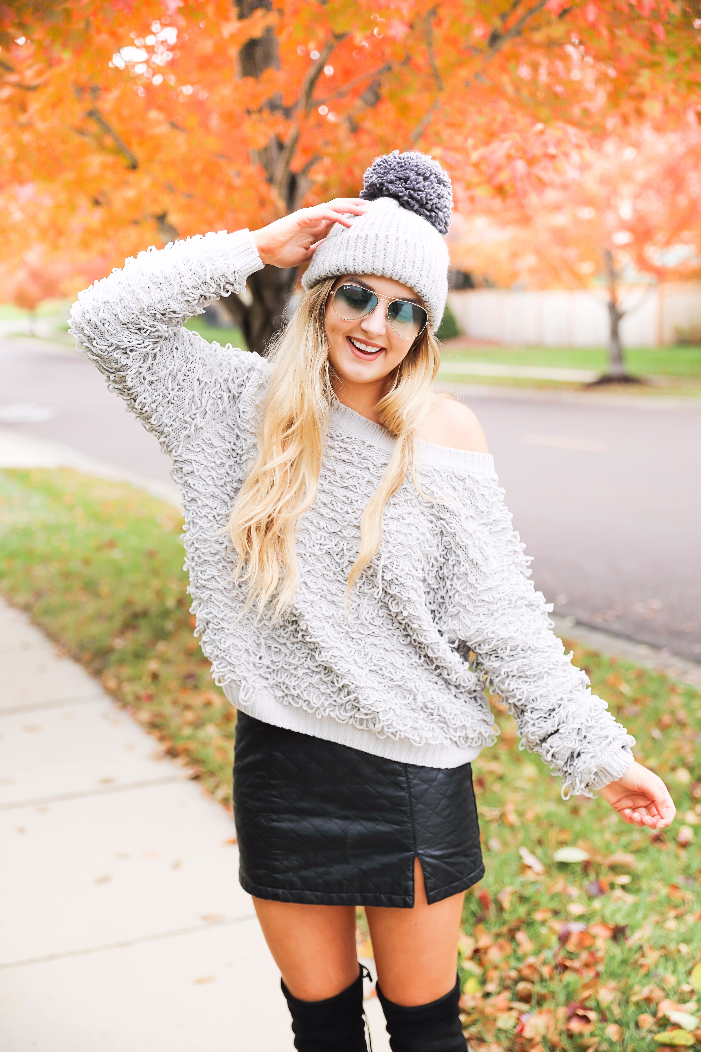 Grey loop sweater with black faux leather skirt and over the knee black boots! Paired with a pom beanie for colder days. Such a cute fall and winter outfit! Find the details on fashion blog daily dose of charm by lauren lindmark