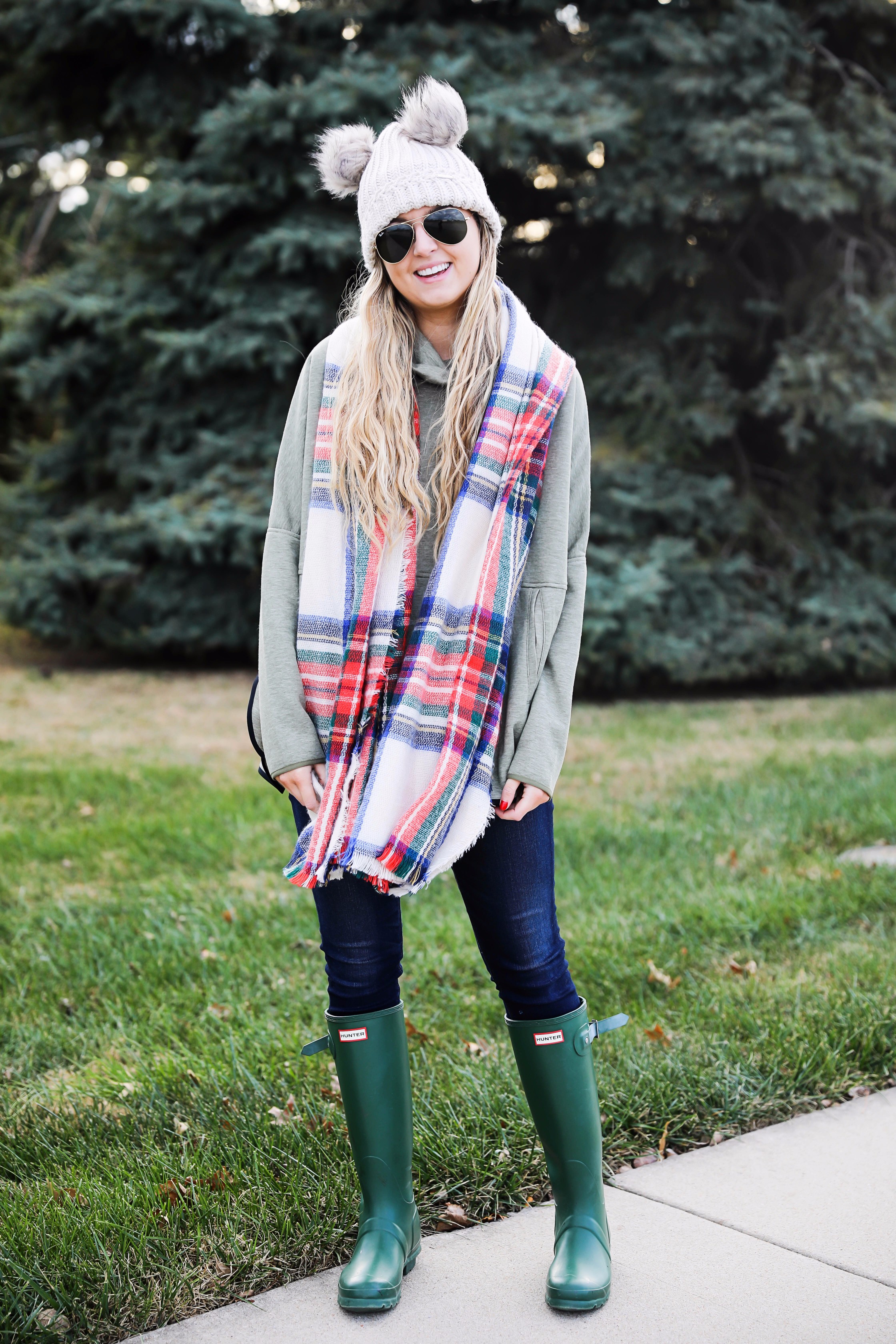 Christmas colored plaid scarf paired with my olive north face and faux fur ear beanie! Wearing my green hunter boots to make this look a casual holiday outfit! Details on daily dose of charm by lauren lindmark