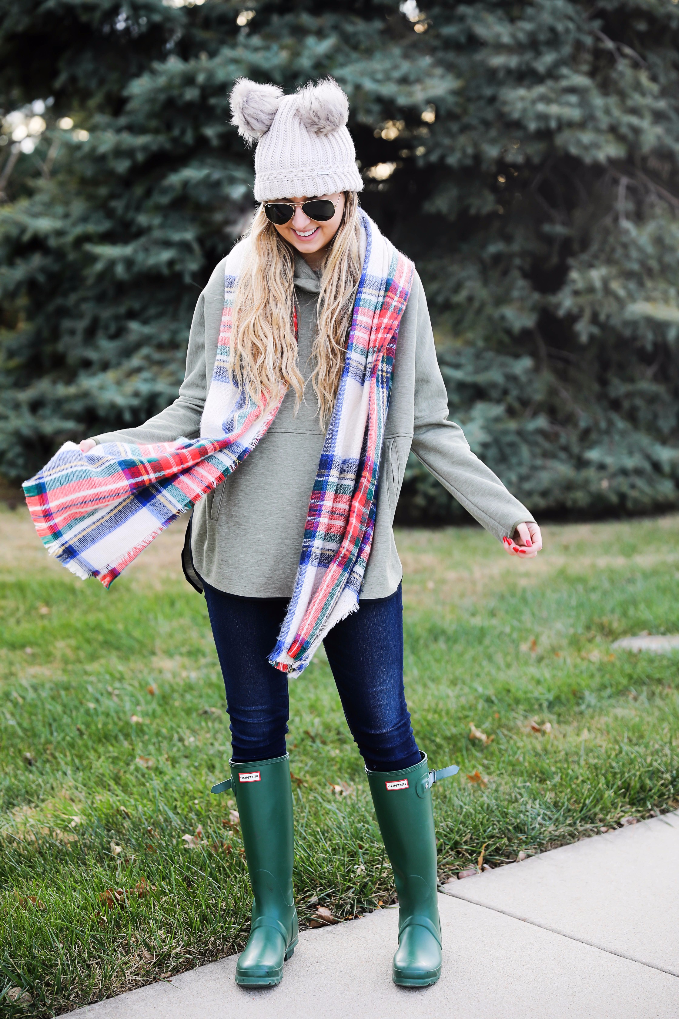 Christmas colored plaid scarf paired with my olive north face and faux fur ear beanie! Wearing my green hunter boots to make this look a casual holiday outfit! Details on daily dose of charm by lauren lindmark