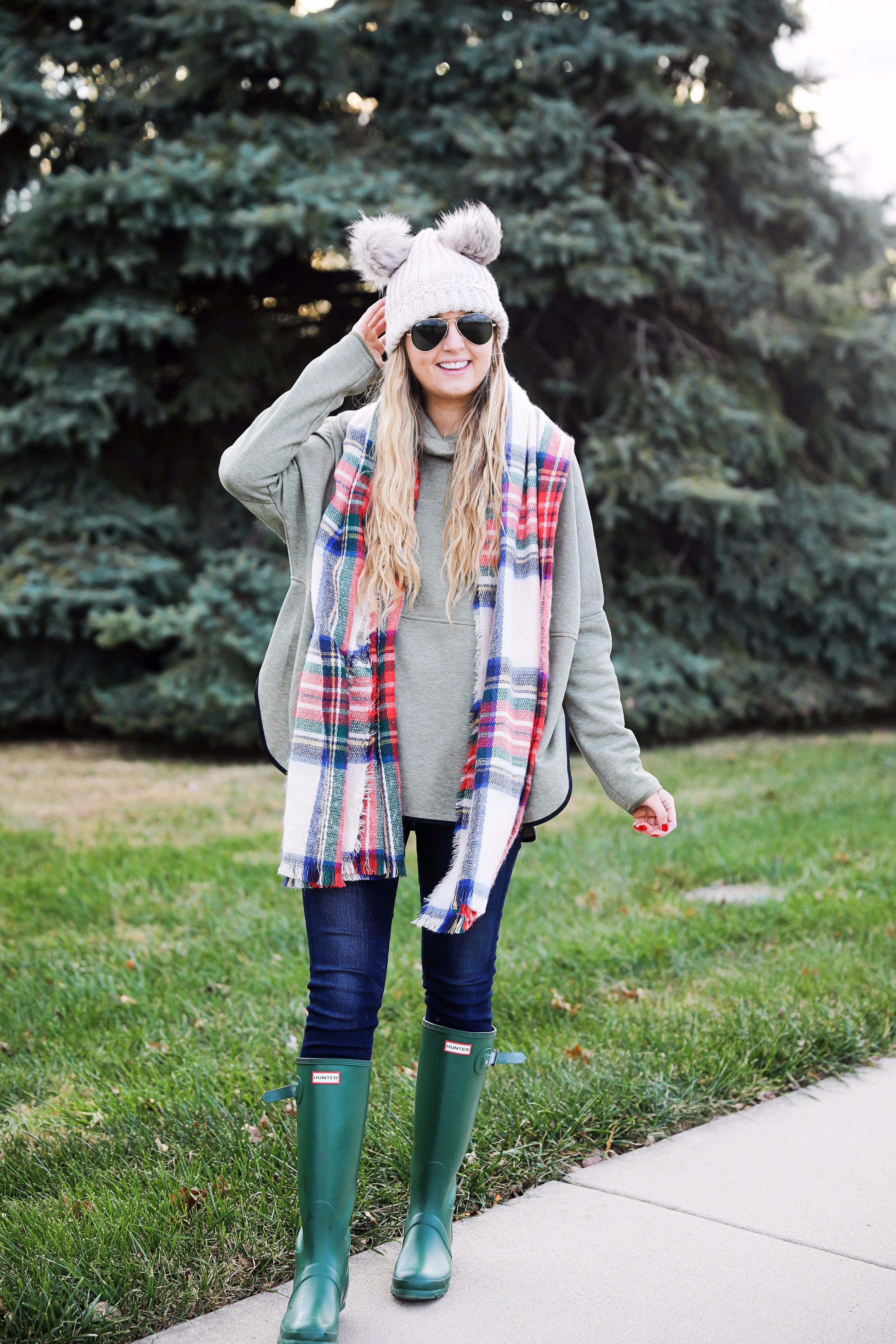 Christmas colored plaid scarf paired with my olive north face and faux fur ear beanie! Wearing my green hunter boots to make this look a casual holiday outfit! Details on daily dose of charm by lauren lindmark