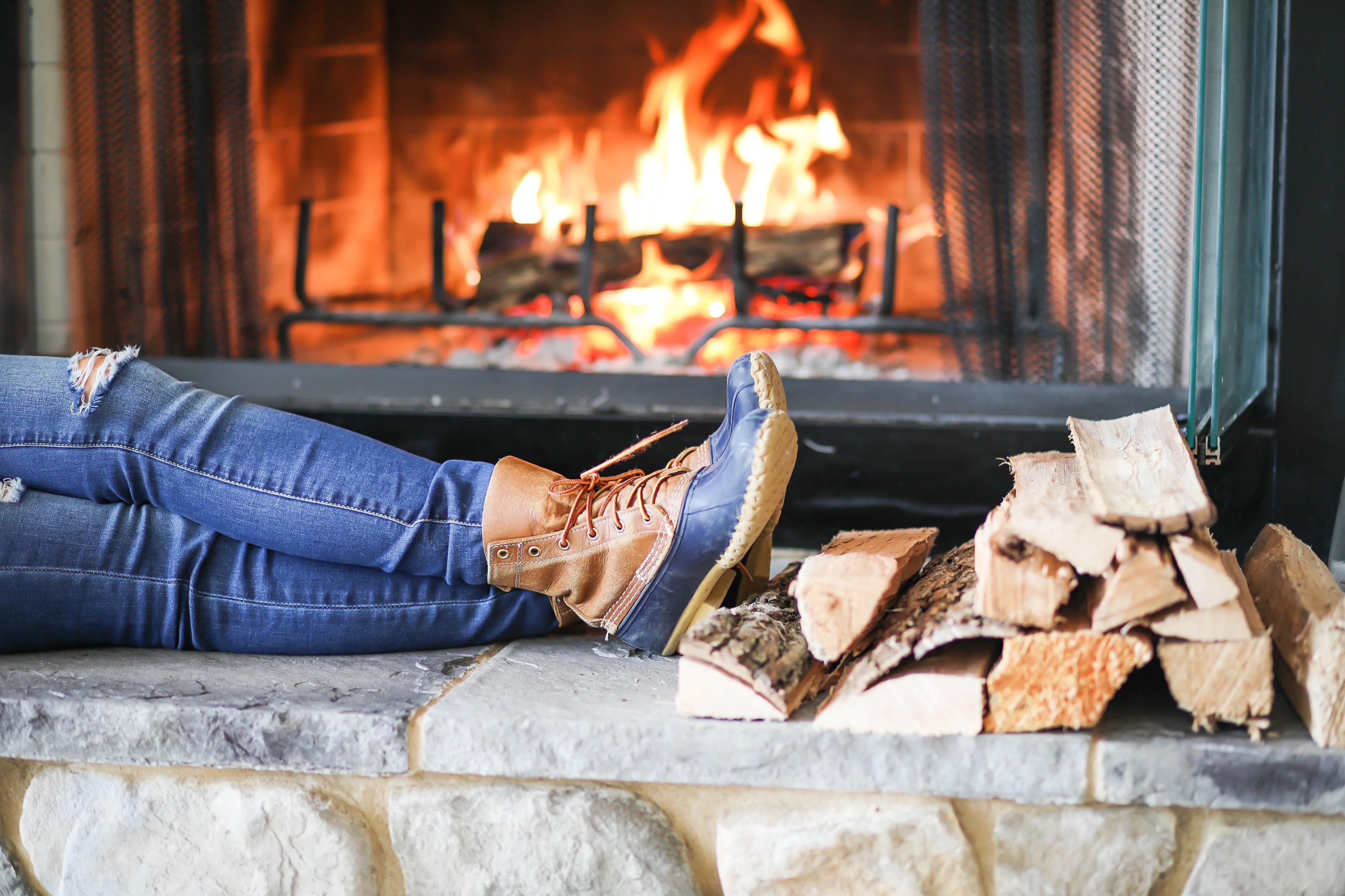 Cozy cable knit sweater in front of stone fireplace! This winter cable knit sweater is so cute and the fire looks so inviting! I paired it with my L.L. Bean duck Boots! Details on fashion blog daily dose of charm by lauren lindmark