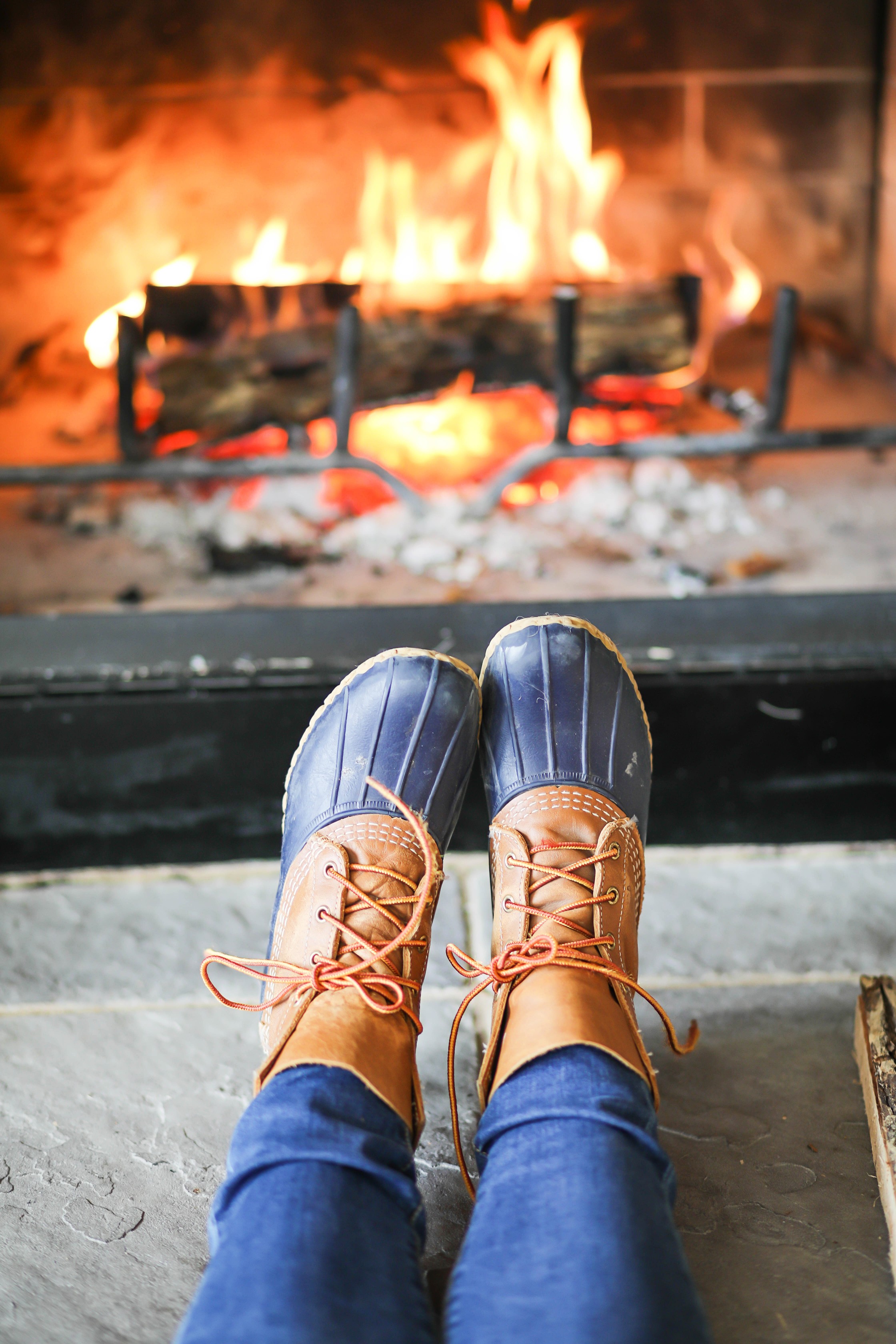 Cozy cable knit sweater in front of stone fireplace! This winter cable knit sweater is so cute and the fire looks so inviting! I paired it with my L.L. Bean duck Boots! Details on fashion blog daily dose of charm by lauren lindmark