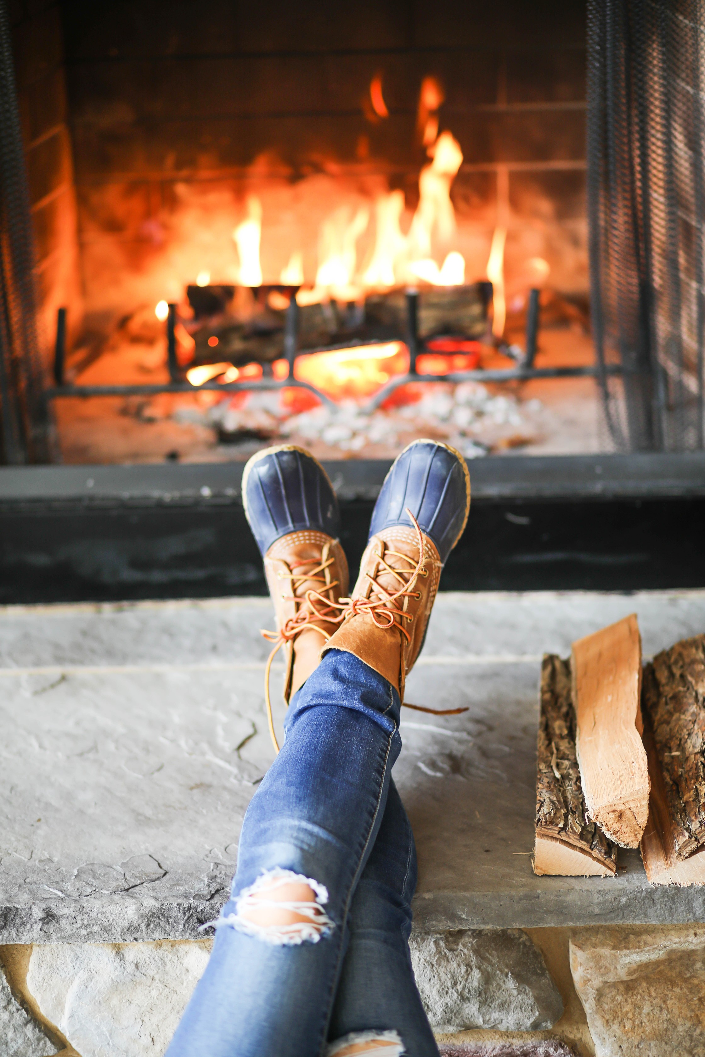 Cozy cable knit sweater in front of stone fireplace! This winter cable knit sweater is so cute and the fire looks so inviting! I paired it with my L.L. Bean duck Boots! Details on fashion blog daily dose of charm by lauren lindmark