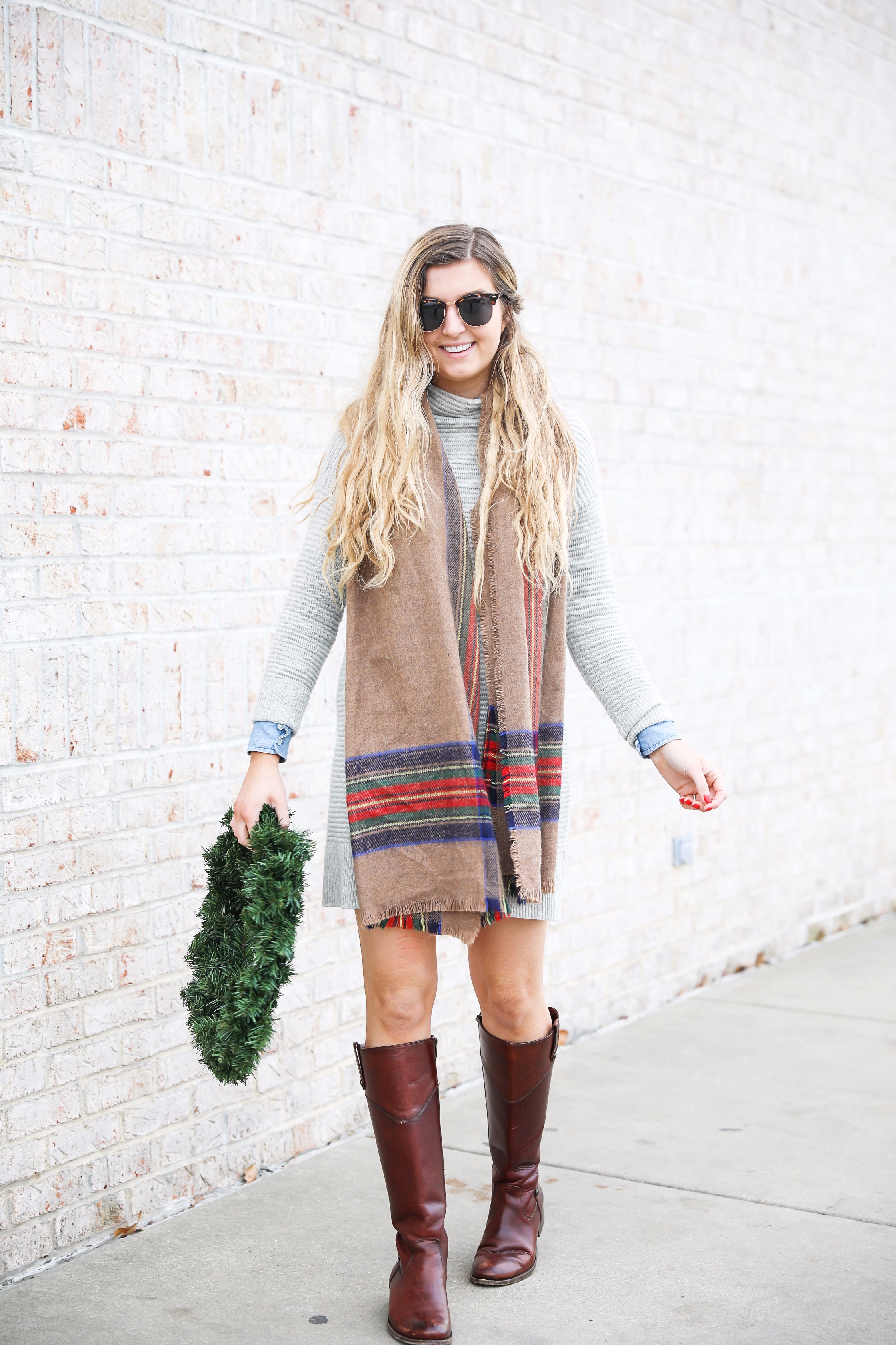 Grey sweater dress layered wtih a chambray top and plaid scarf! Paired with my favorite riding boots by frye boots! Photos taken with a christmas wreath. Christmas wreath photos by lauren lindmark on the blog daily dose of charm