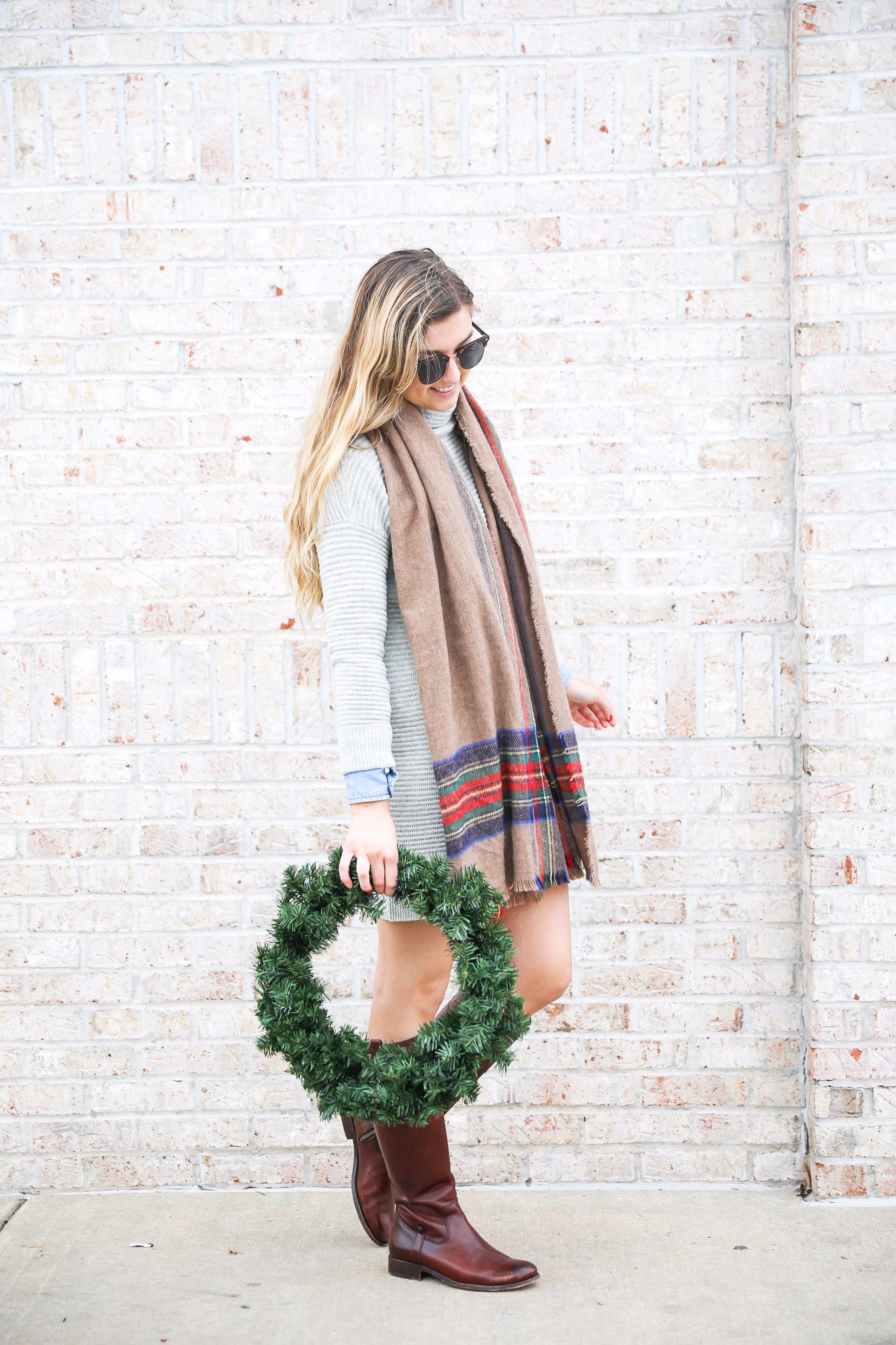 Grey sweater dress layered wtih a chambray top and plaid scarf! Paired with my favorite riding boots by frye boots! Photos taken with a christmas wreath. Christmas wreath photos by lauren lindmark on the blog daily dose of charm