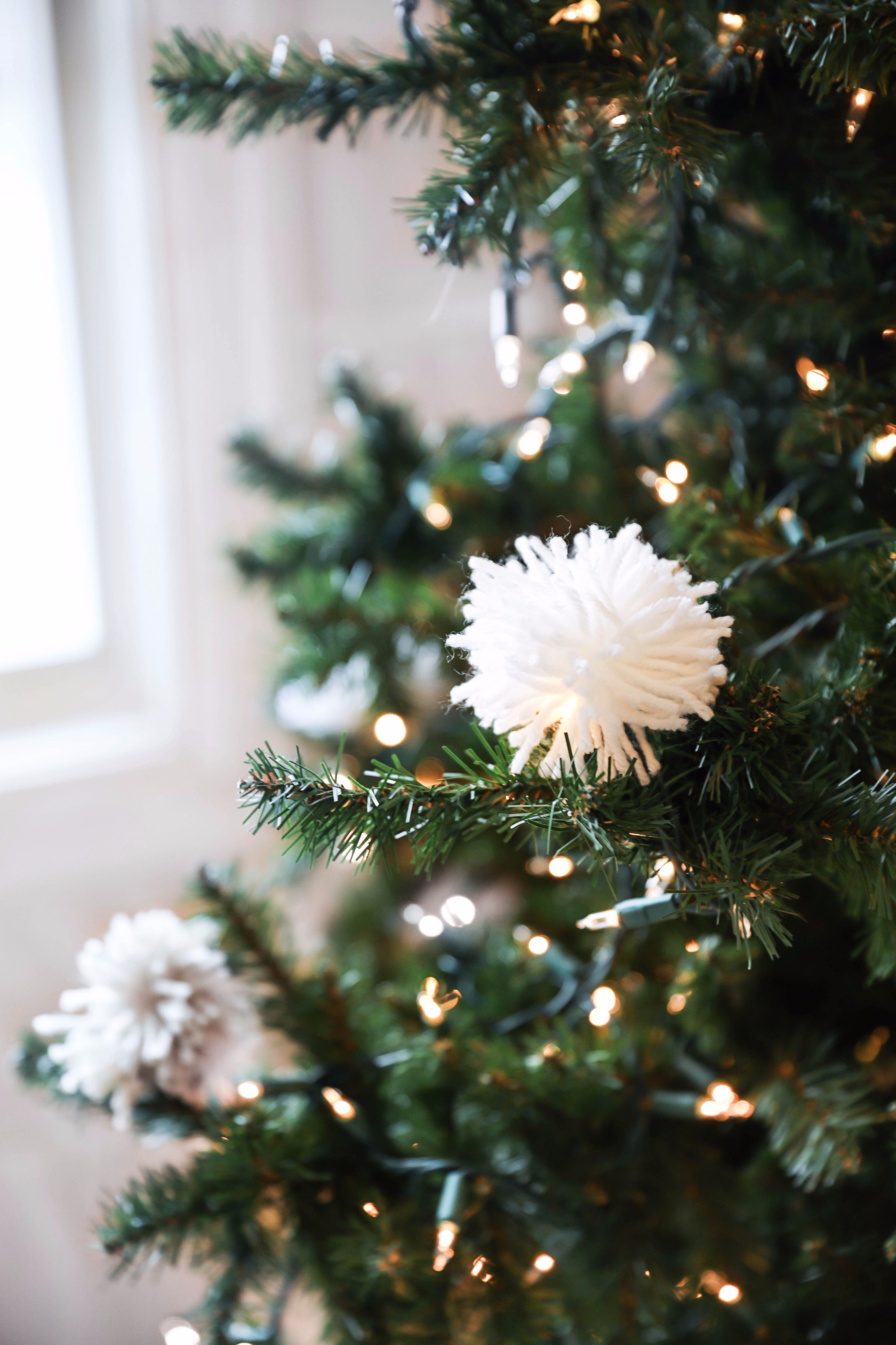 Holiday DIY decor! Learn how to make DIY snowball ornaments, tassel ornaments, pom pom ornaments, pom pom pillows, and pom pom garlands! Details on daily dose of charm lauren lindmark