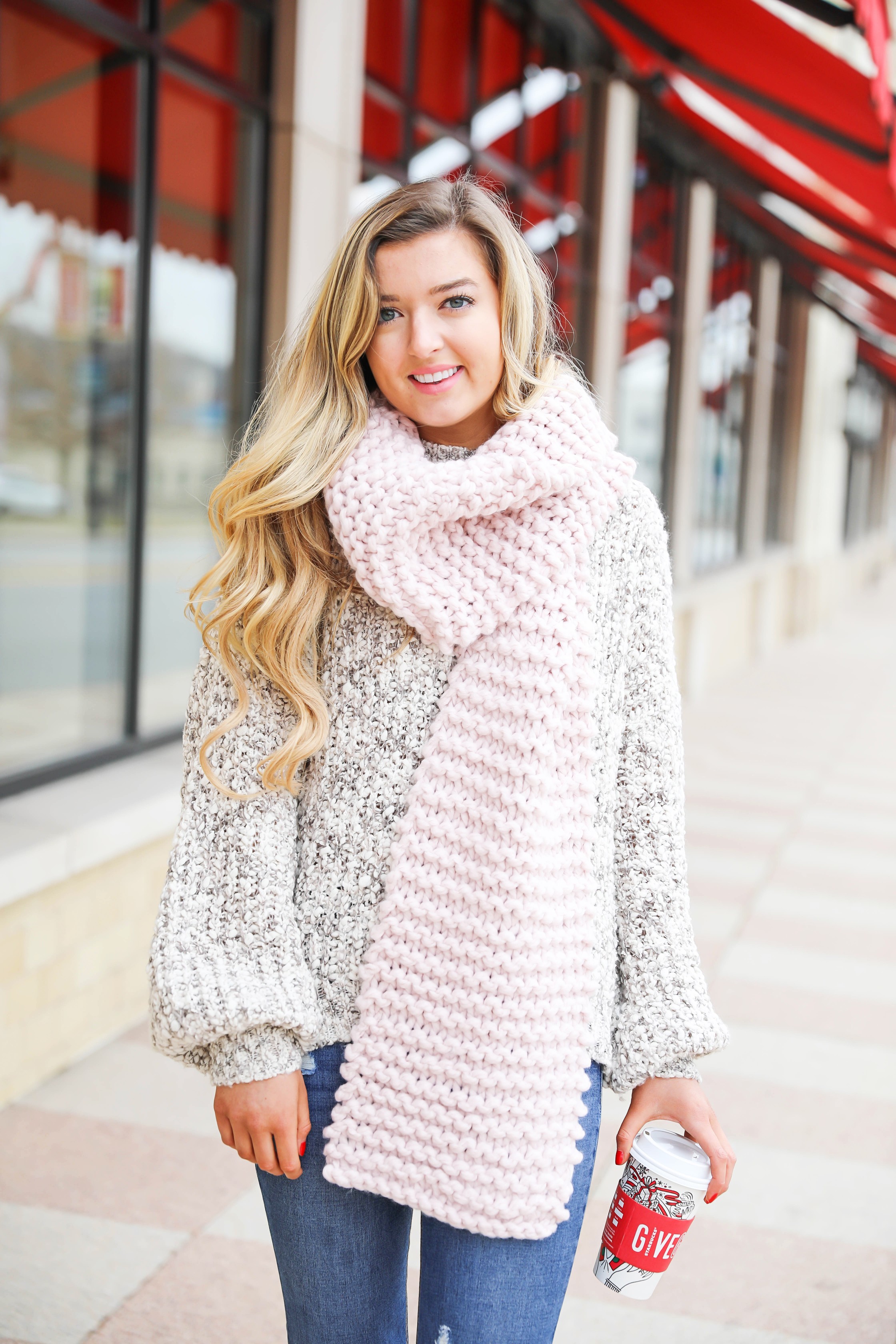 Huge knit scarf and cozy knit sweater with frye riding boots! Such a super cute winter outfit idea! Red cup from Starbucks with a cute winter outfit! Details on fashion blog daily dose of charm lauren lindmark