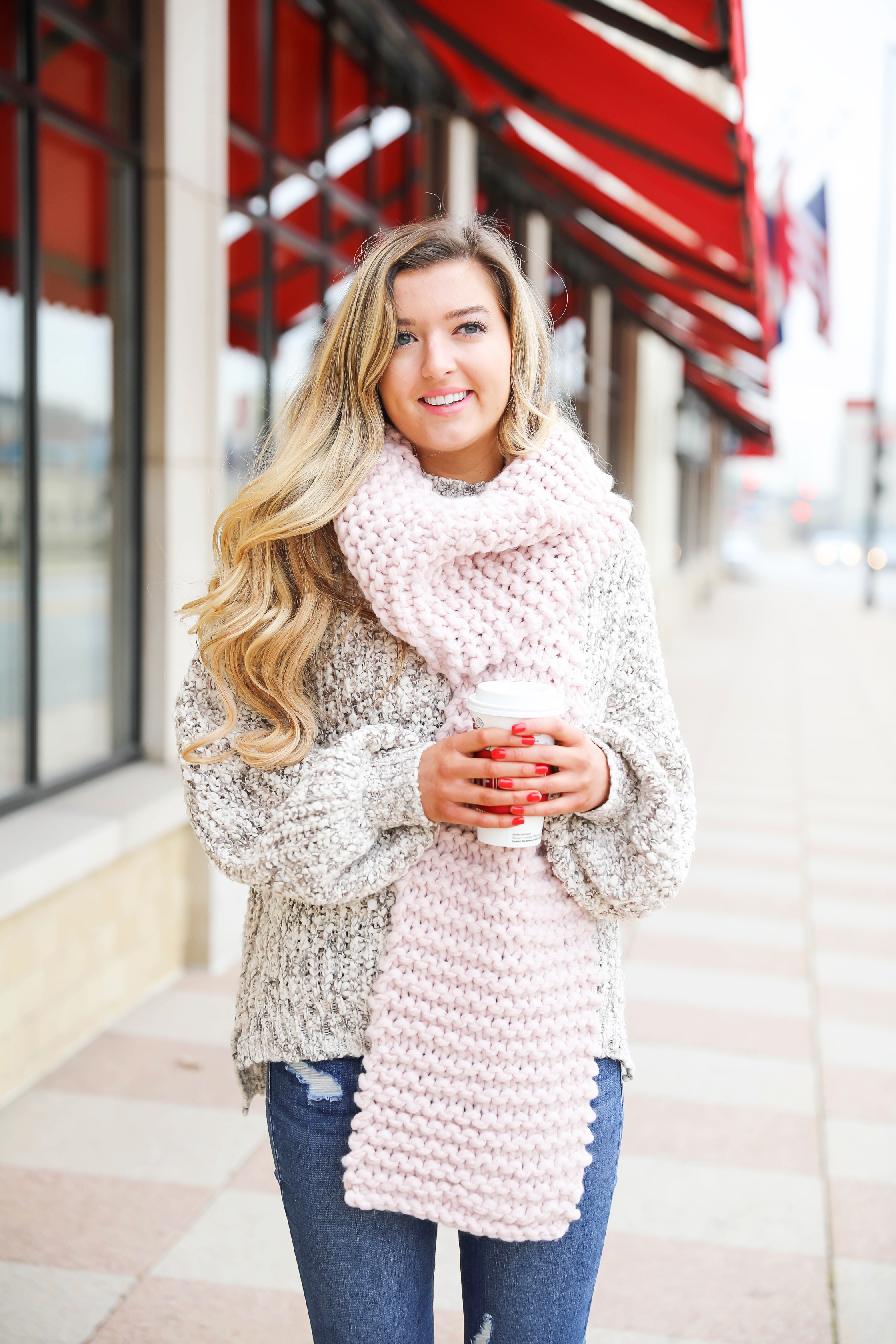 Huge knit scarf and cozy knit sweater with frye riding boots! Such a super cute winter outfit idea! Red cup from Starbucks with a cute winter outfit! Details on fashion blog daily dose of charm lauren lindmark