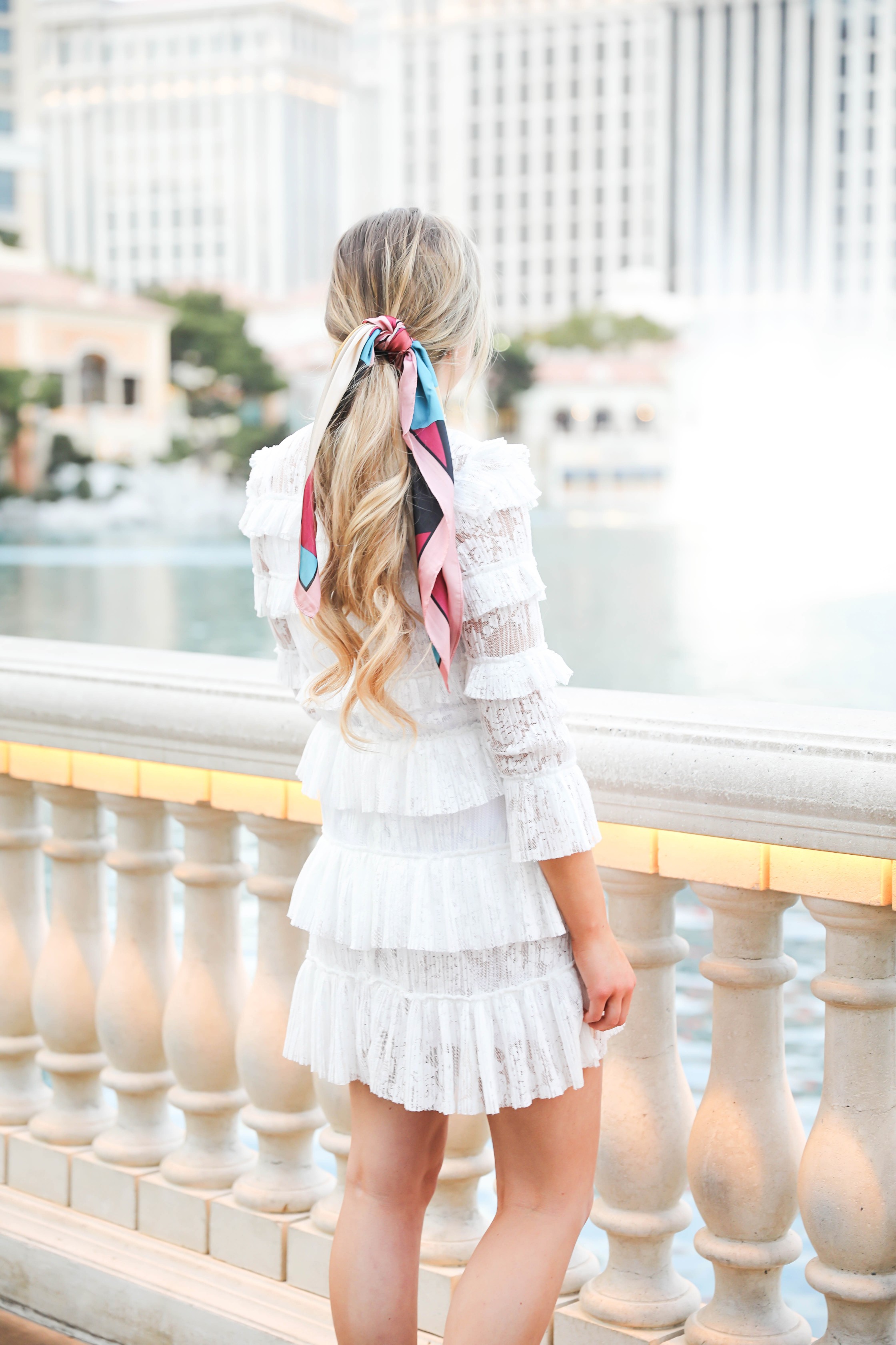 Bellagio fountains in Las Vegas! Wearing a white lace dress and scarf in my pony tail! Las Vegas style! Las vegas blogger! Details on daily dose of charm by lauren lindmark