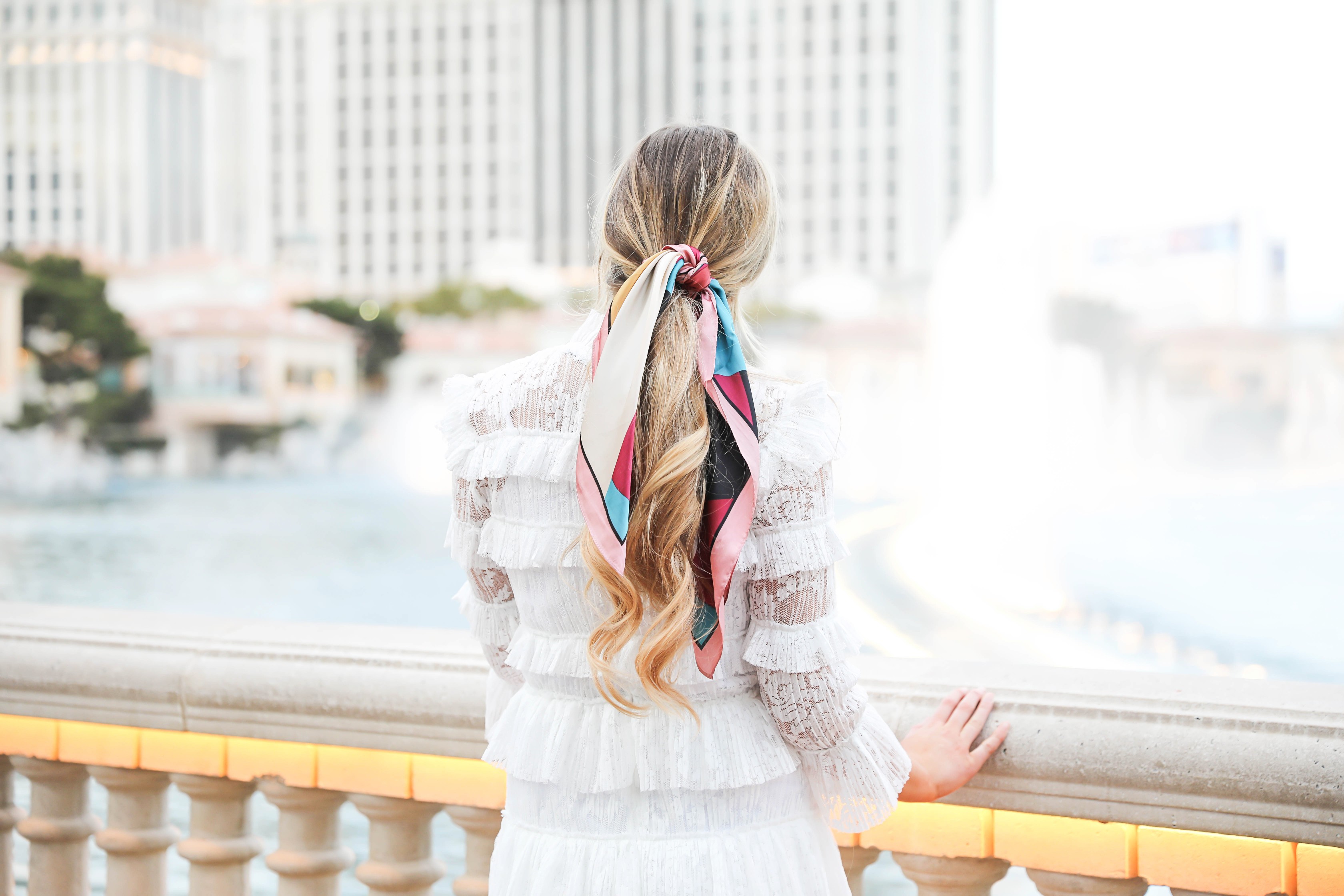 Bellagio fountains in Las Vegas! Wearing a white lace dress and scarf in my pony tail! Las Vegas style! Las vegas blogger! Details on daily dose of charm by lauren lindmark