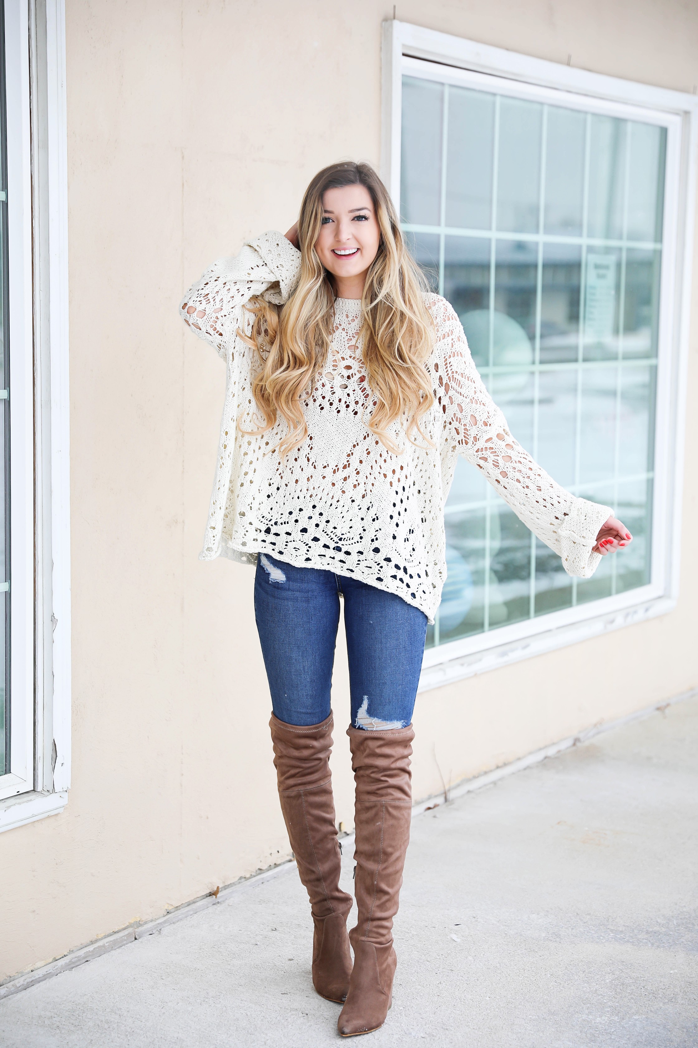 Free People crochet sweater and rust orange bralette peaking through the sweater! Love it with these over the knee boots and ripped denim jeans! Find the details on fashion blog daily dose of charm by lauren lindmark