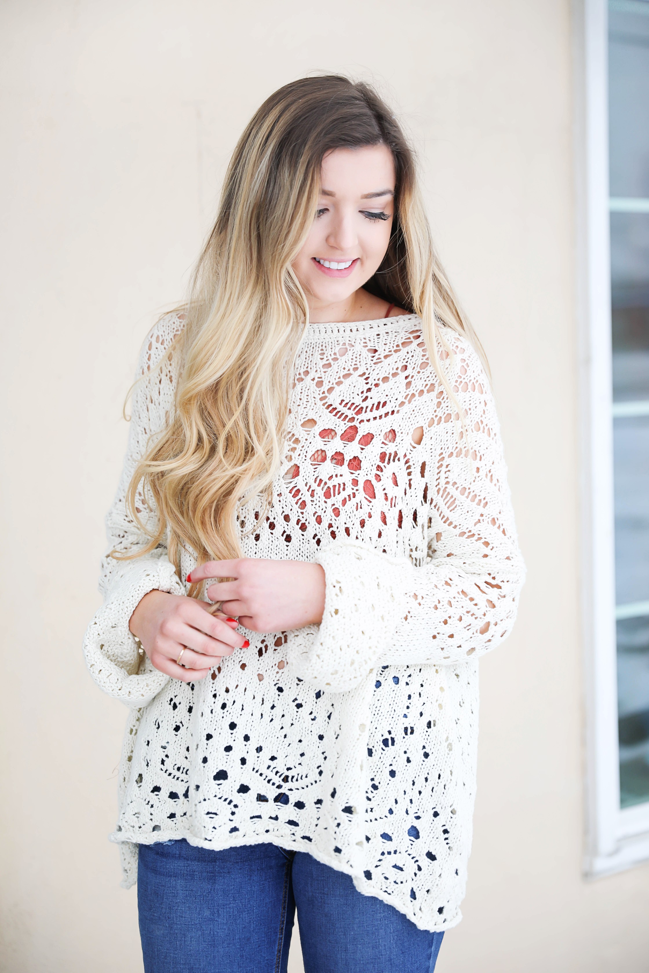 Free People crochet sweater and rust orange bralette peaking through the sweater! Love it with these over the knee boots and ripped denim jeans! Find the details on fashion blog daily dose of charm by lauren lindmark