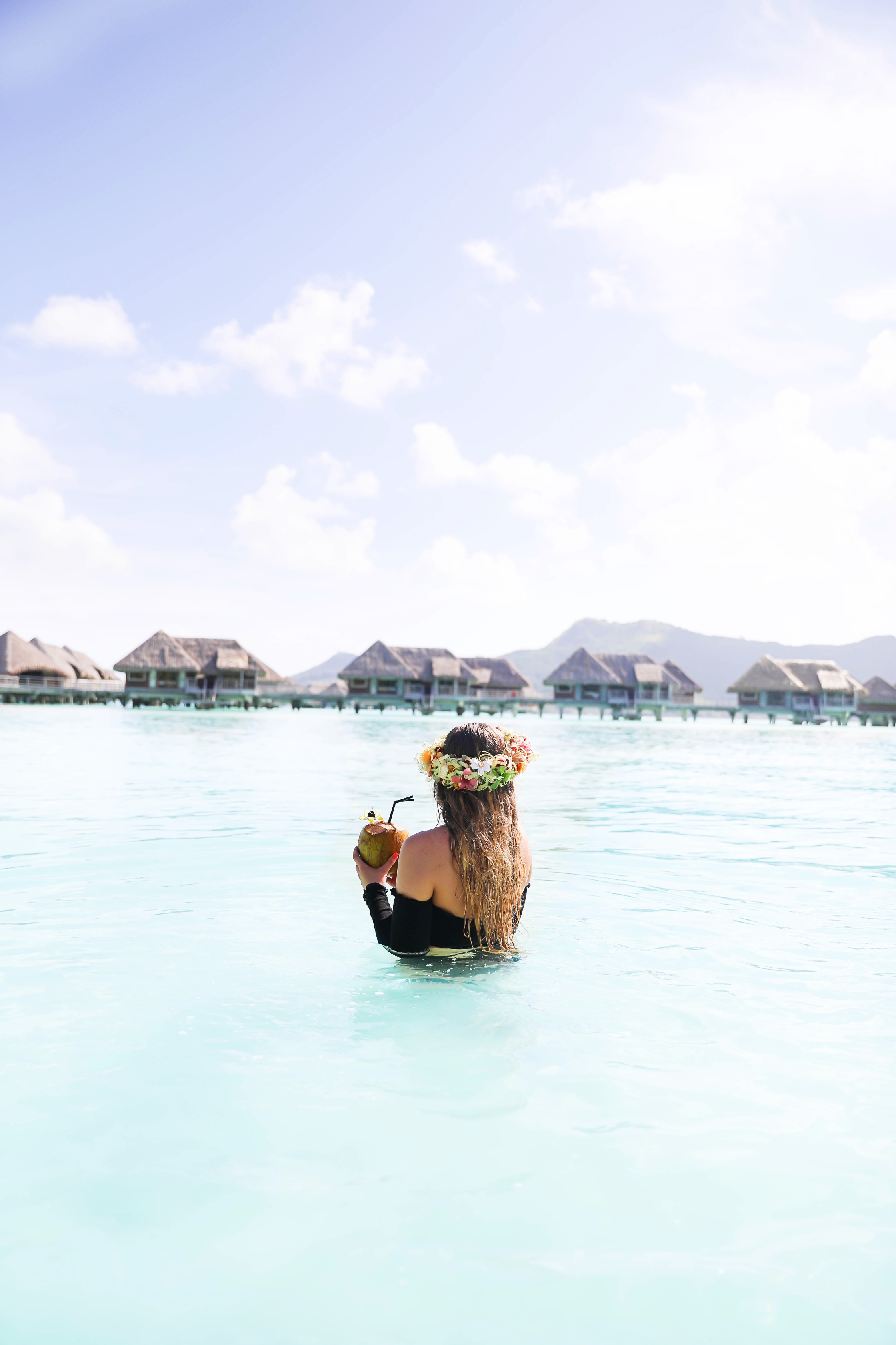 Coconut drink in bora bora, French Polynesia at the Intercontinental Hotel Thelasso! Cute beach photo and vacation photo inspiration! This black two piece high waisted long sleeve swimsuit bikini is my favorite! Details on travel blog Daily Dose of Charm by fashion blogger Lauren lindmark! 