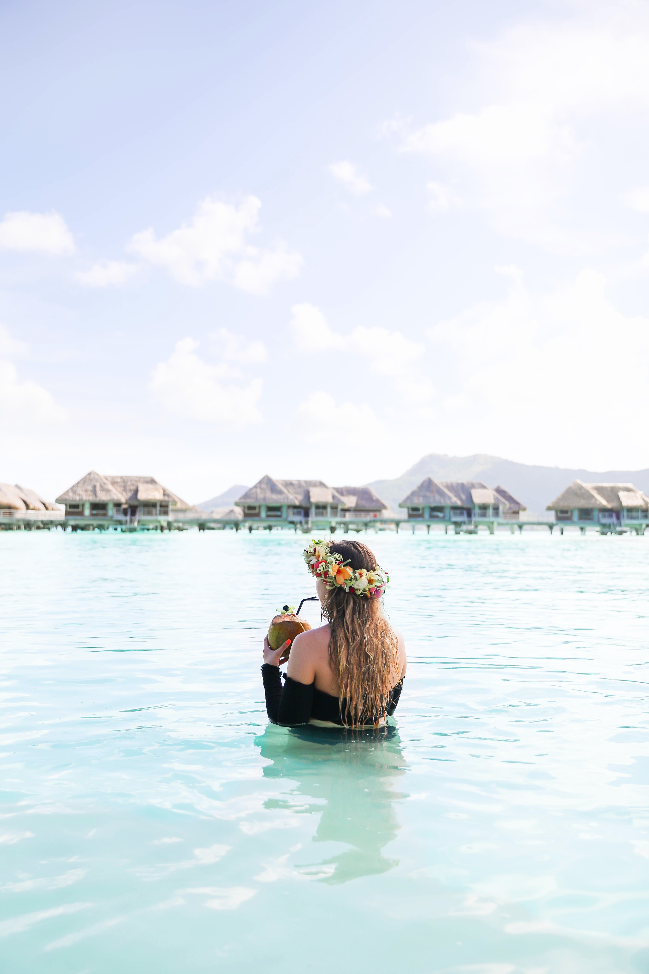 Coconut drink in bora bora, French Polynesia at the Intercontinental Hotel Thelasso! Cute beach photo and vacation photo inspiration! This black two piece high waisted long sleeve swimsuit bikini is my favorite! Details on travel blog Daily Dose of Charm by fashion blogger Lauren lindmark! 