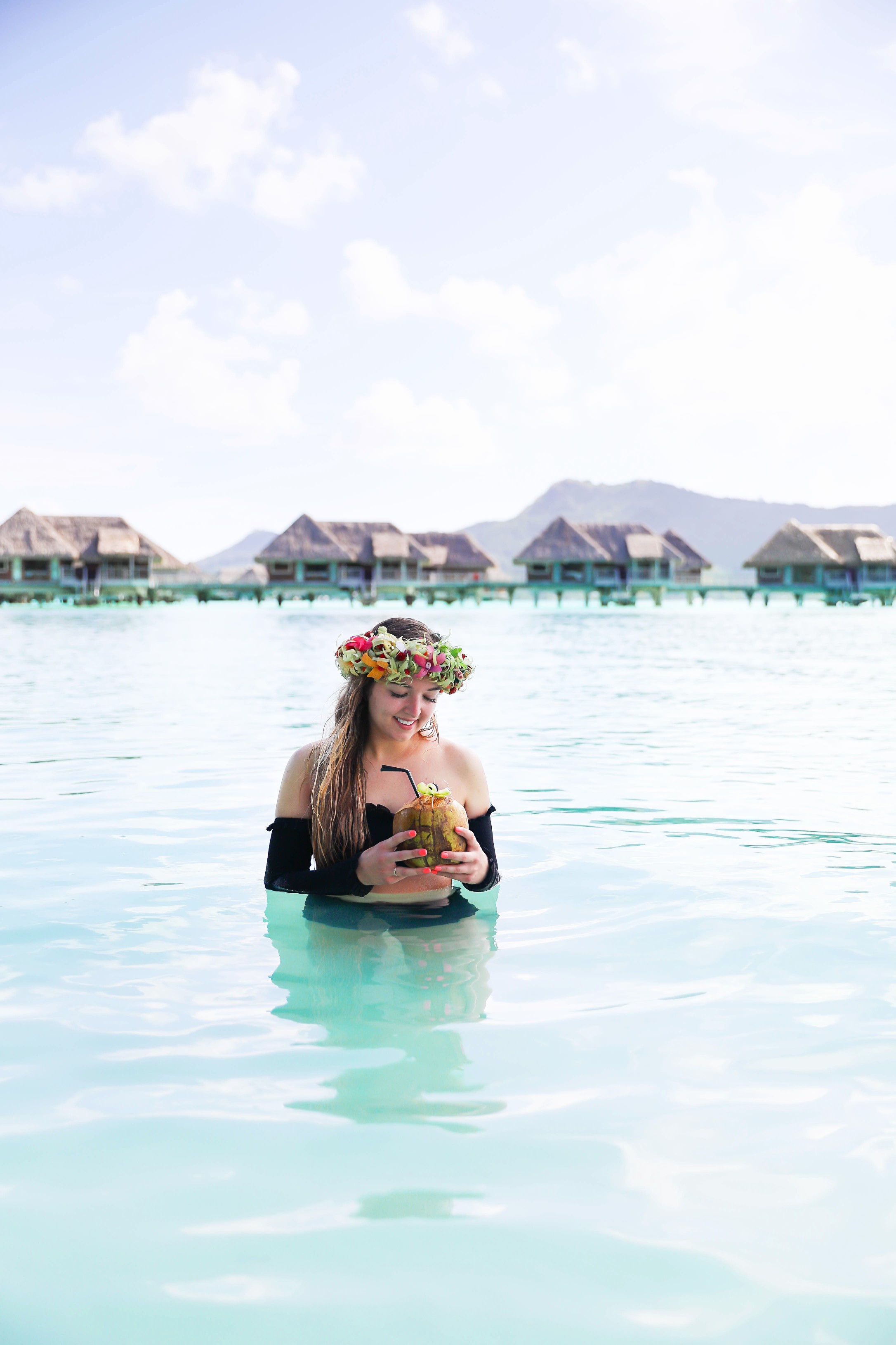 Coconut drink in bora bora, French Polynesia at the Intercontinental Hotel Thelasso! Cute beach photo and vacation photo inspiration! This black two piece high waisted long sleeve swimsuit bikini is my favorite! Details on travel blog Daily Dose of Charm by fashion blogger Lauren lindmark! 