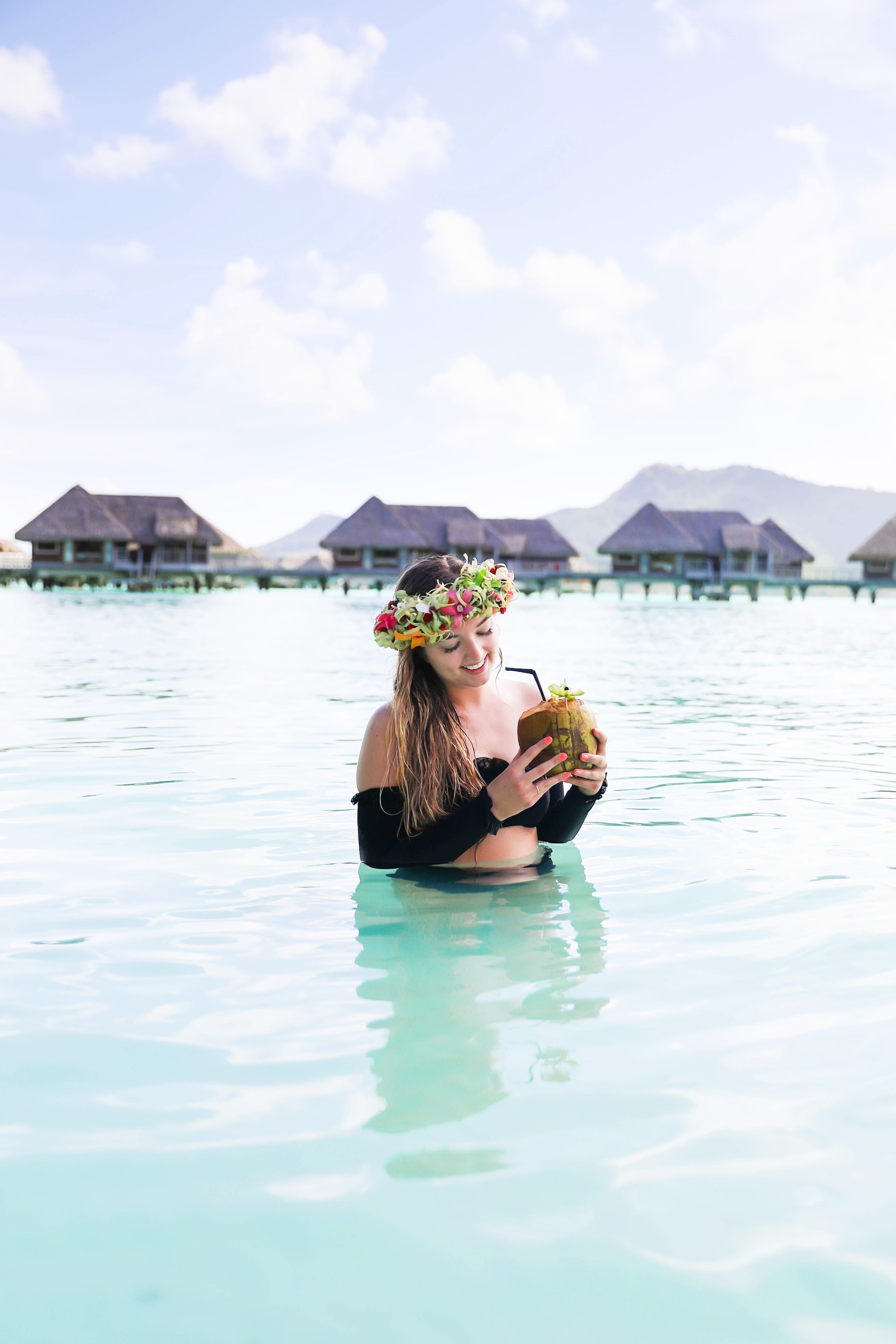 Coconut drink in bora bora, French Polynesia at the Intercontinental Hotel Thelasso! Cute beach photo and vacation photo inspiration! This black two piece high waisted long sleeve swimsuit bikini is my favorite! Details on travel blog Daily Dose of Charm by fashion blogger Lauren lindmark! 