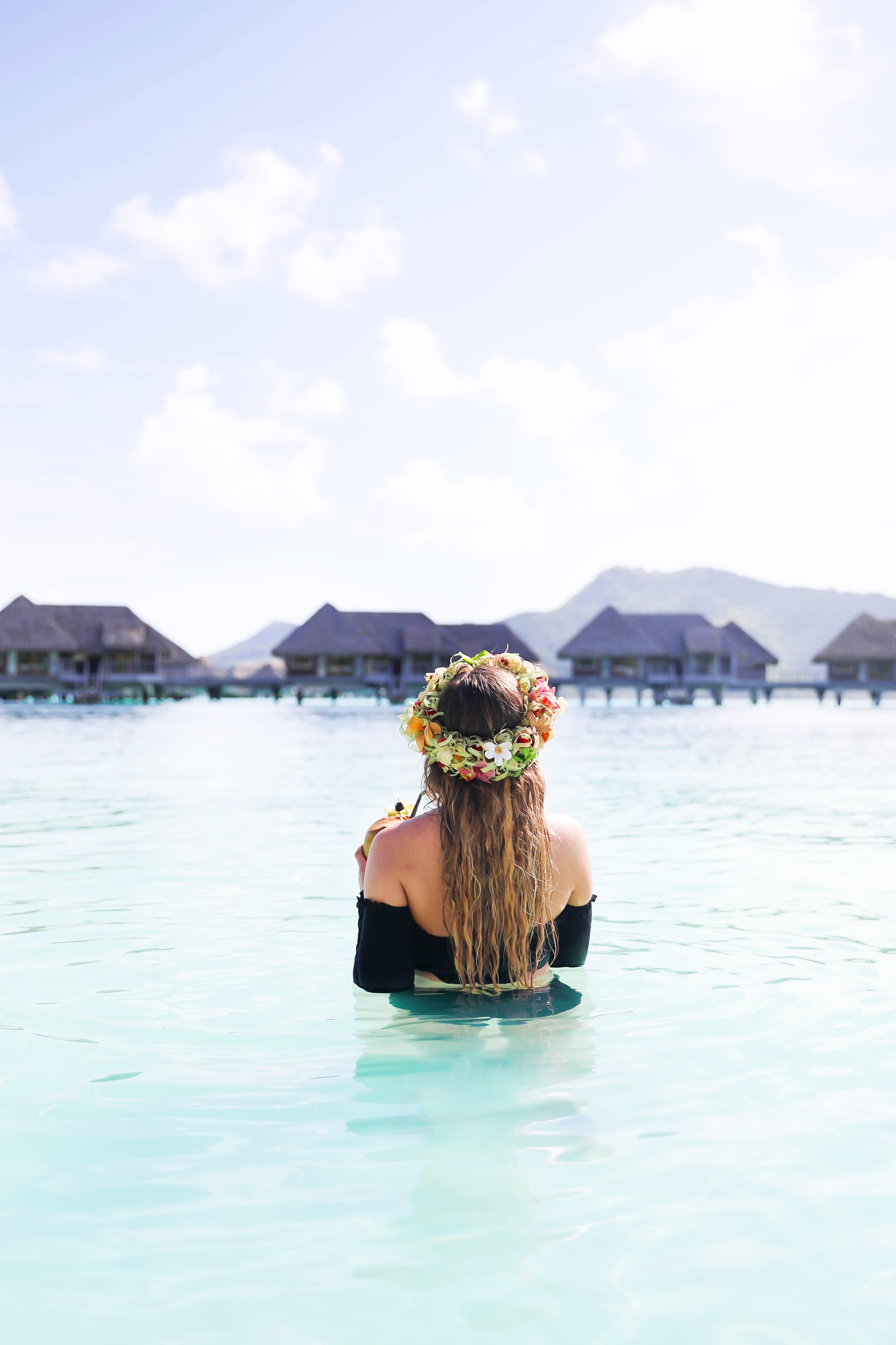 Coconut drink in bora bora, French Polynesia at the Intercontinental Hotel Thelasso! Cute beach photo and vacation photo inspiration! This black two piece high waisted long sleeve swimsuit bikini is my favorite! Details on travel blog Daily Dose of Charm by fashion blogger Lauren lindmark! 