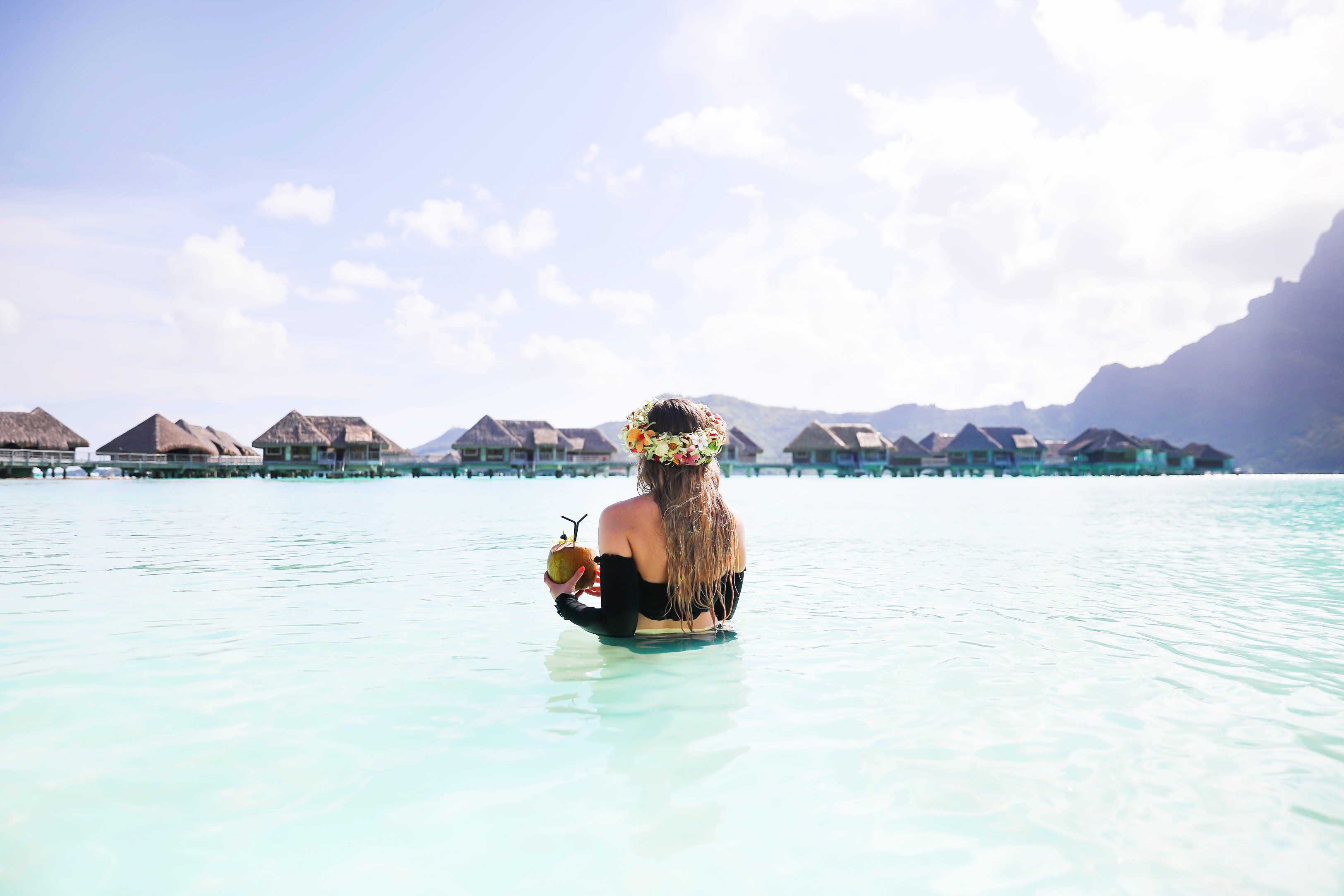 Coconut drink in bora bora, French Polynesia at the Intercontinental Hotel Thelasso! Cute beach photo and vacation photo inspiration! This black two piece high waisted long sleeve swimsuit bikini is my favorite! Details on travel blog Daily Dose of Charm by fashion blogger Lauren lindmark!