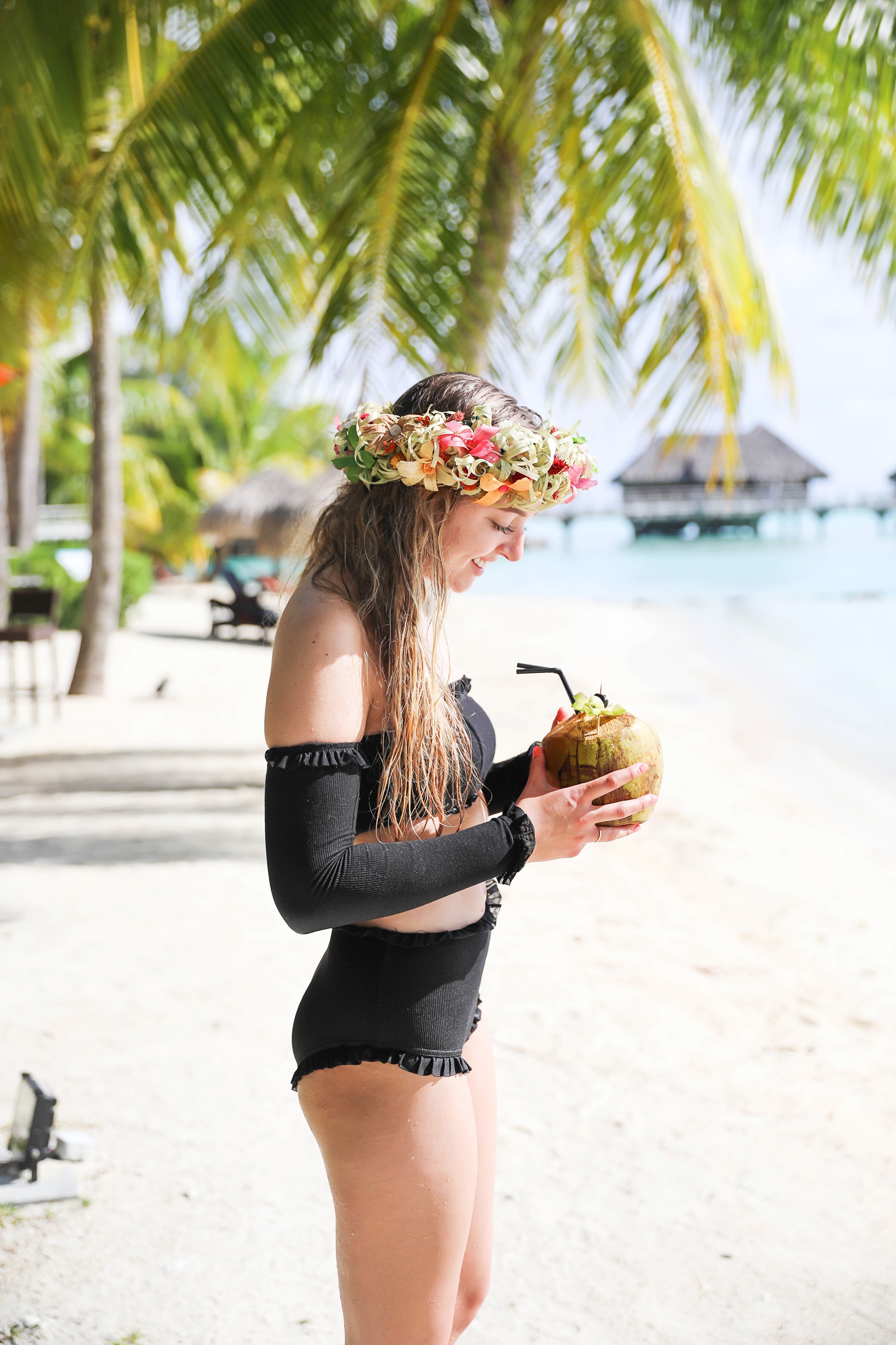 Coconut drink in bora bora, French Polynesia at the Intercontinental Hotel Thelasso! Cute beach photo and vacation photo inspiration! This black two piece high waisted long sleeve swimsuit bikini is my favorite! Details on travel blog Daily Dose of Charm by fashion blogger Lauren lindmark! 