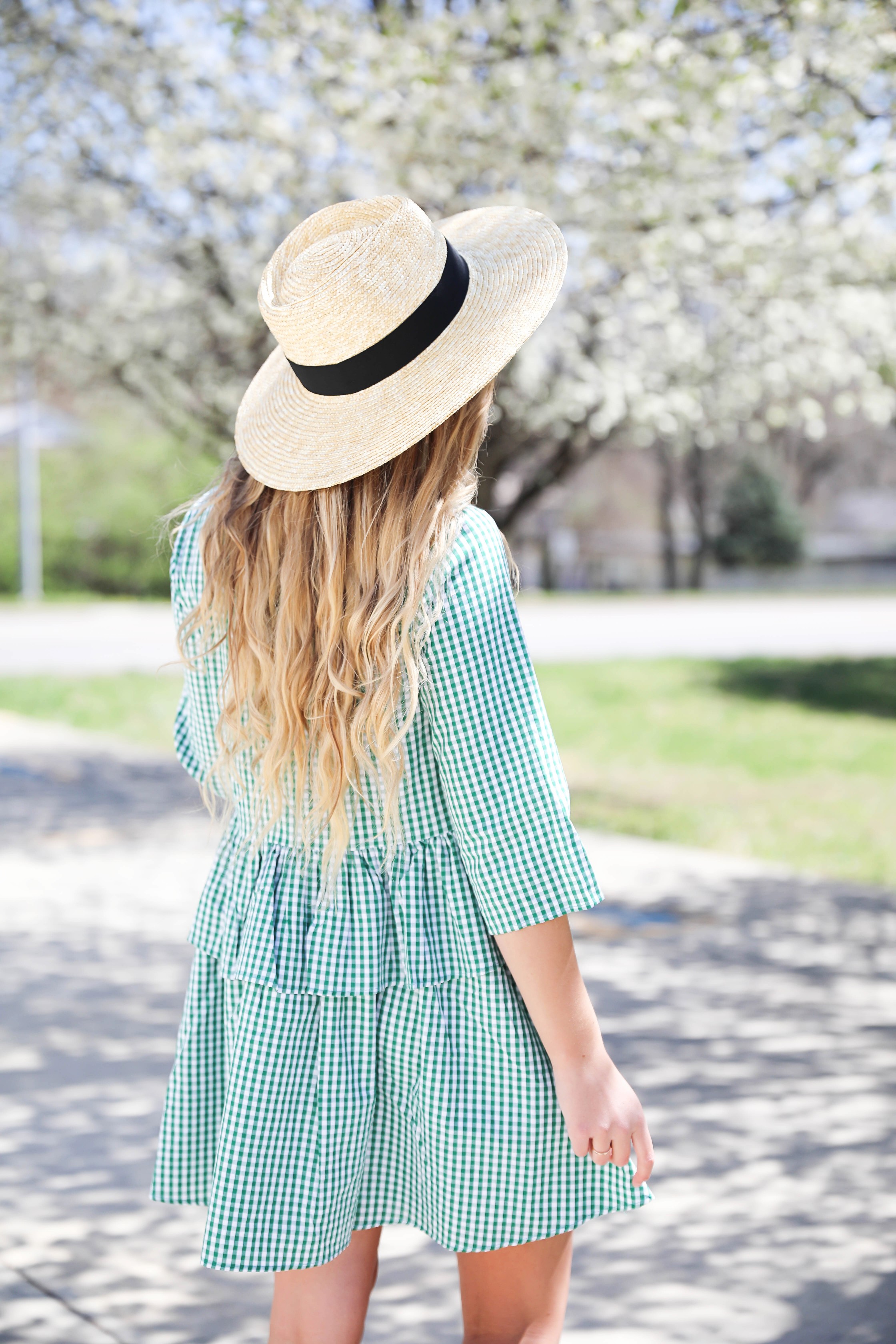 Green gingham dress perfect for spring days or days on the beach! I paired it with a straw hat and blue earrings! The most beautiful spring blooming trees were in the background making this spring fashion look perfection! Details on fashion blog daily dose of charm by lauren lindmark