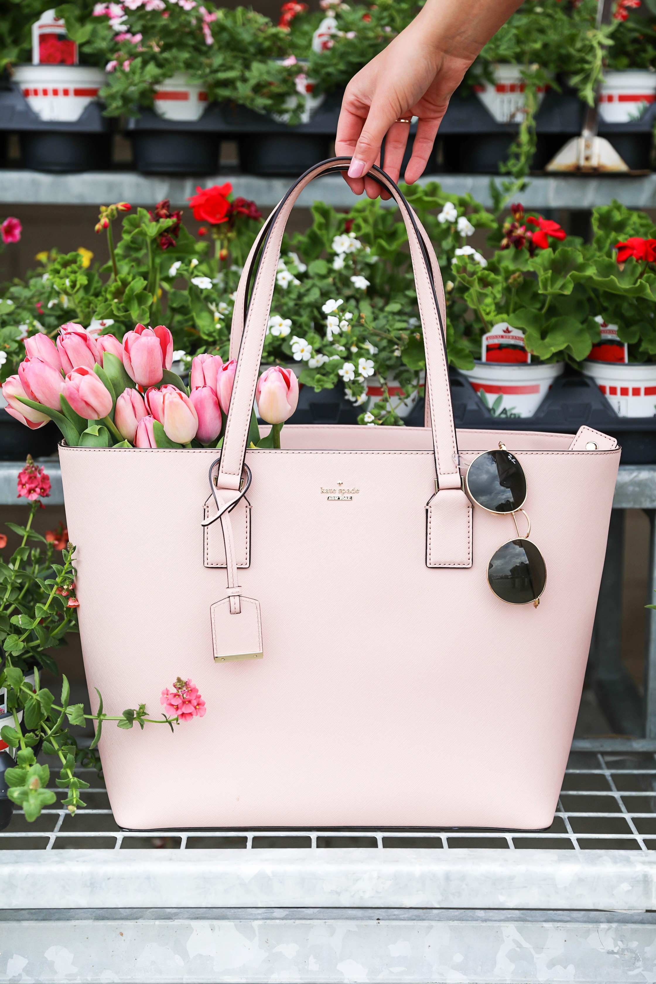 Pink romper with a cinched waist paired with a pink Kate Spade tote with flowers! These photos were taken at a flower nursery! Such a cute spring outfit, details on fashion blog daily dose of charm by lauren lindmark
