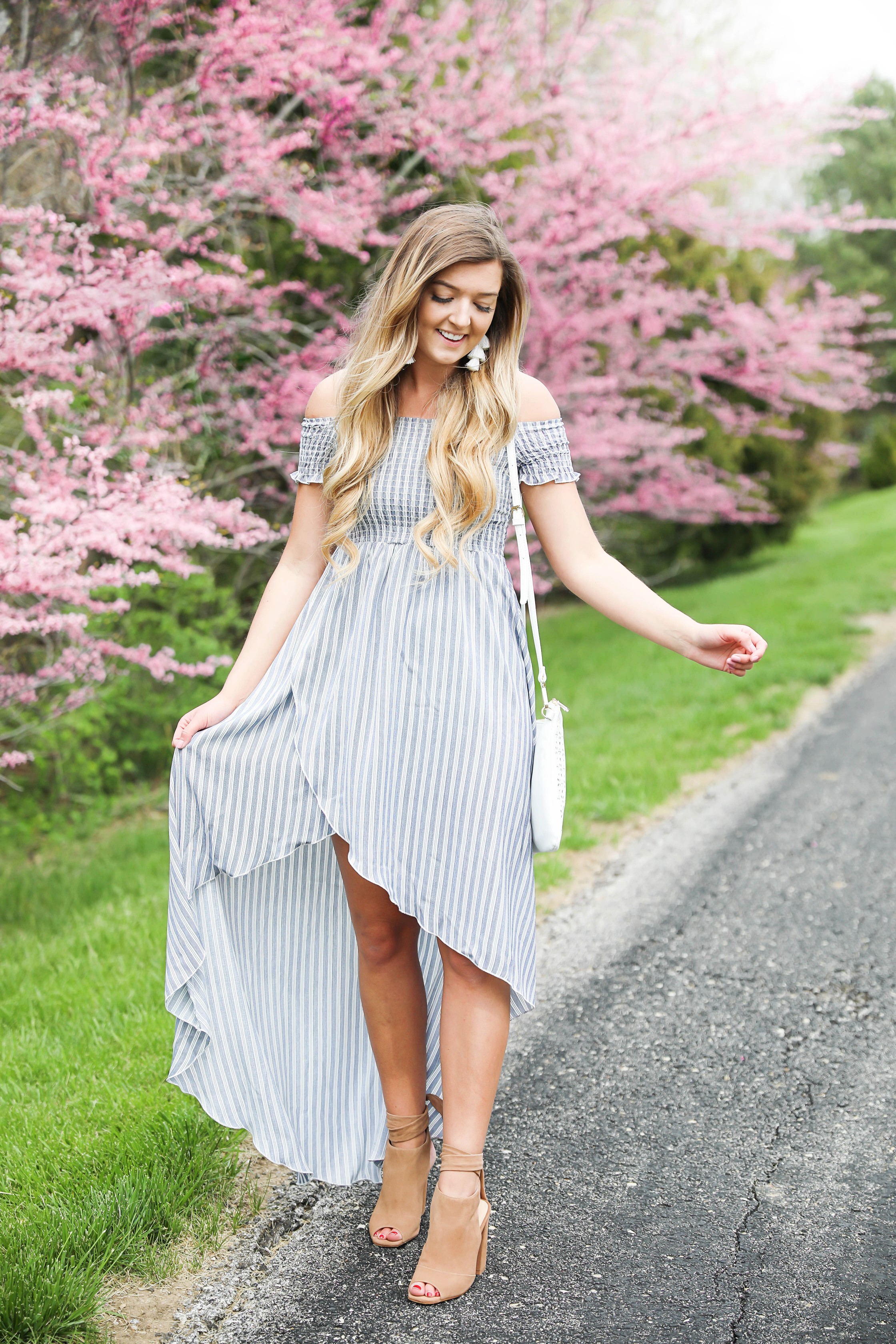 Show me your mumu striped high low maxi dress! Paired with adorable tie up heels and tassel earrings! Springy pink flower trees tie together this whole photoshoot! Check out this spring outfit on fashion blog daily dose of charm by Lauren Lindmark