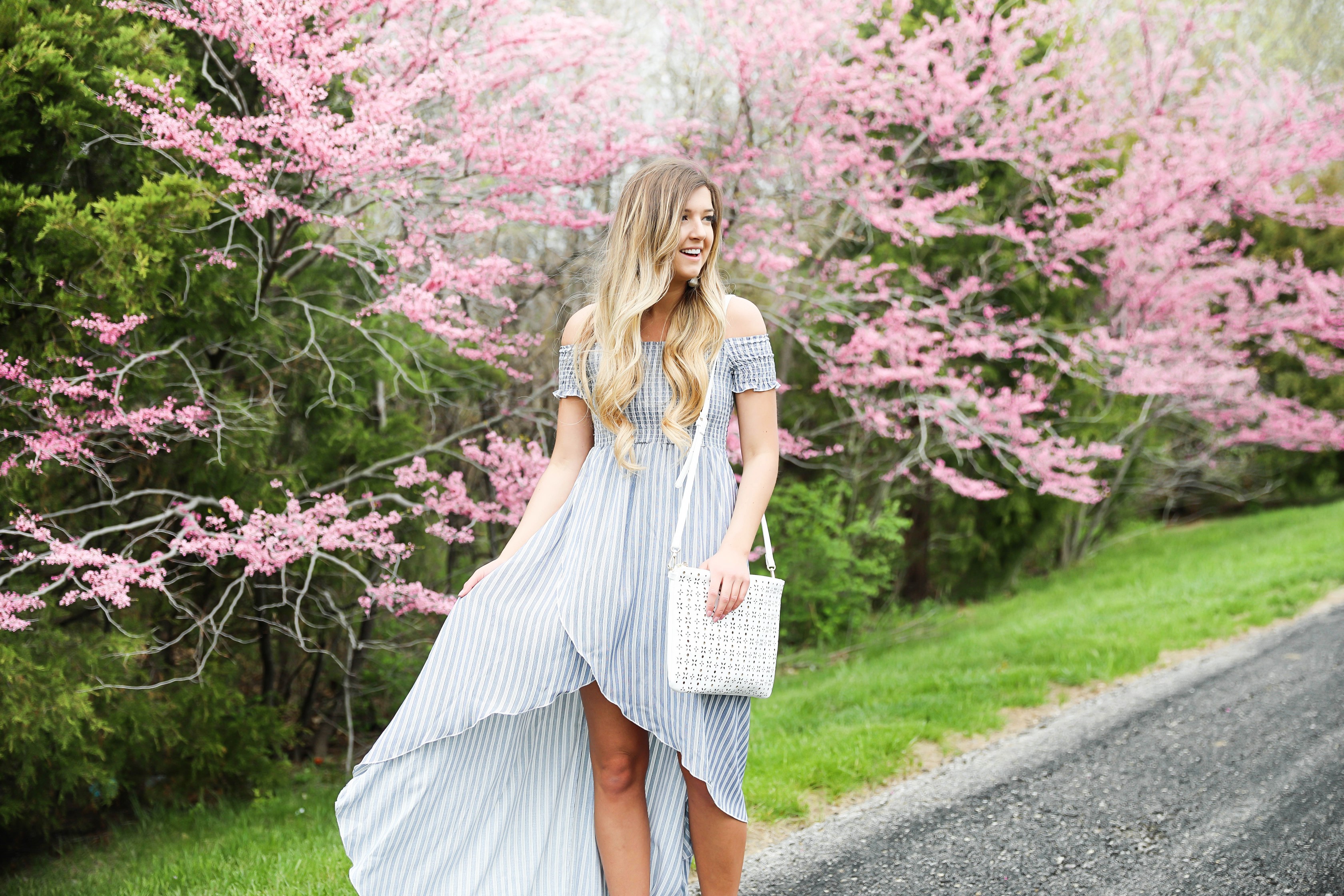 Show me your mumu striped high low maxi dress! Paired with adorable tie up heels and tassel earrings! Springy pink flower trees tie together this whole photoshoot! Check out this spring outfit on fashion blog daily dose of charm by Lauren Lindmark