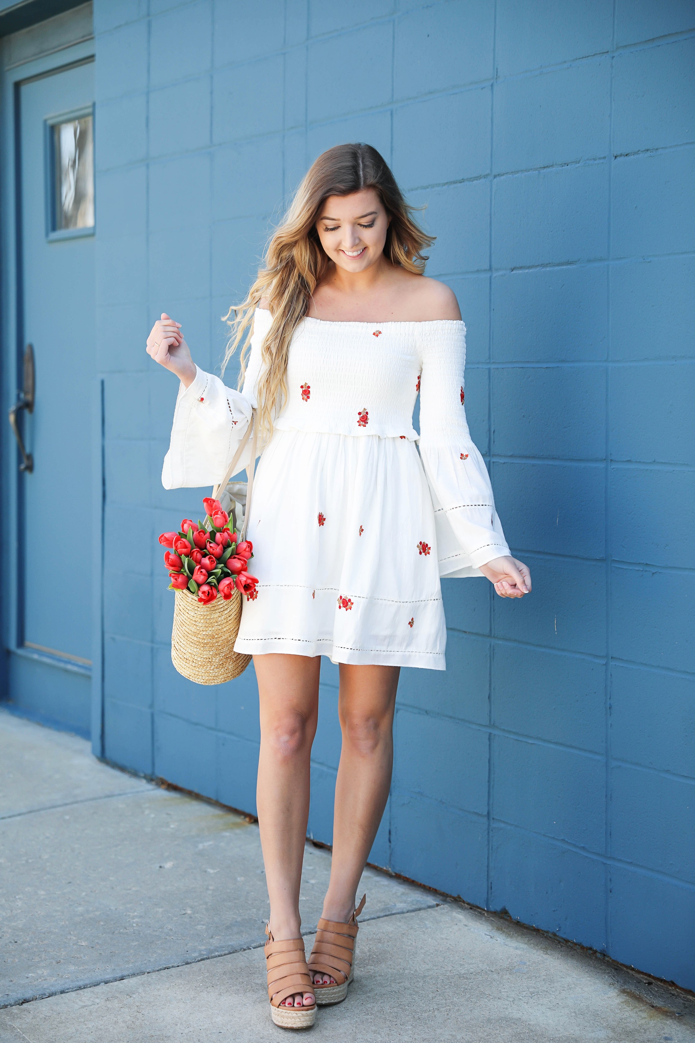 White off the shoulder dress with red embroidery by Free People! Love this look with red tulips in a straw bag and cute wedges! Perfect spring look on fashion blog daily dose of charm by lauren lindmark