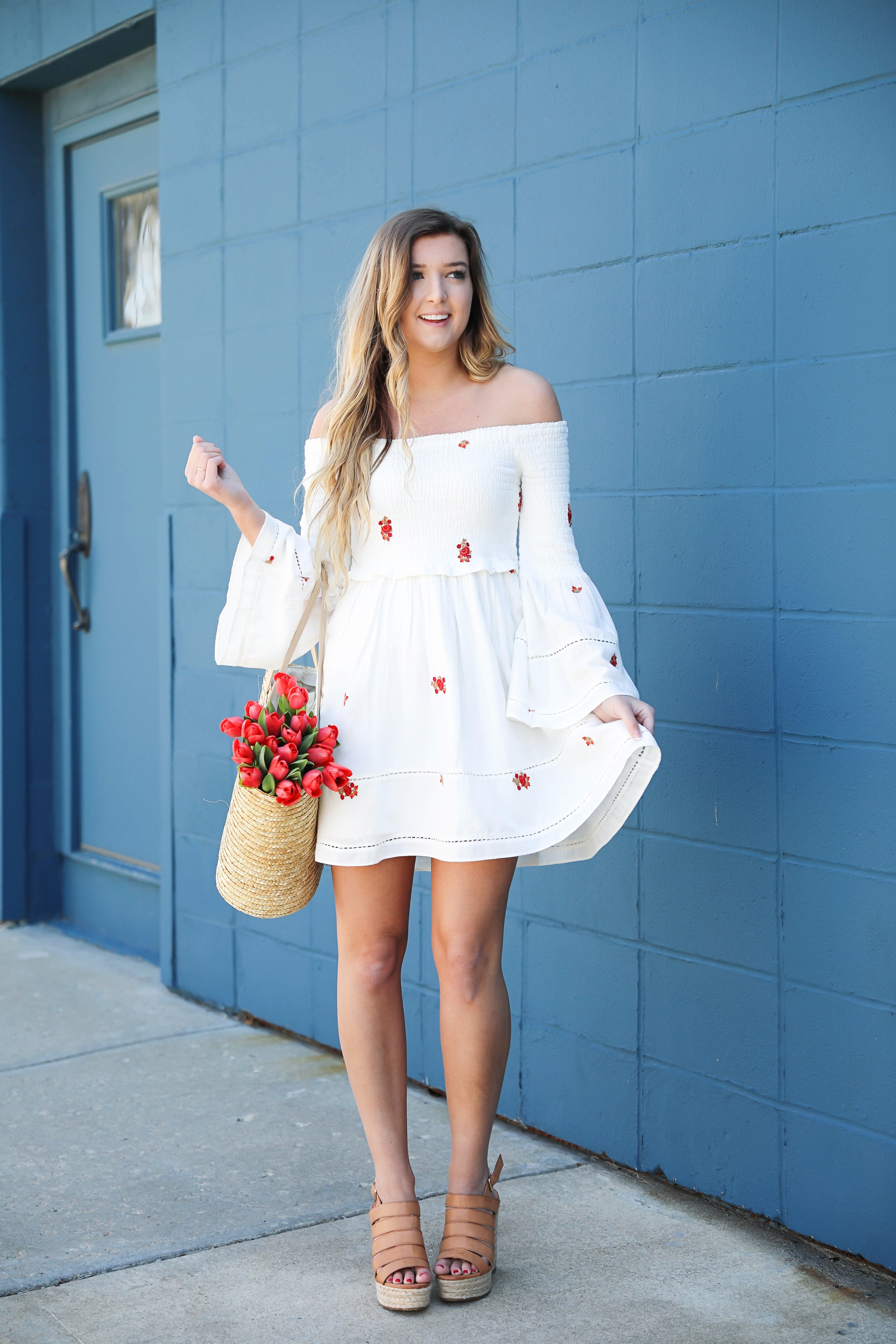 White off the shoulder dress with red embroidery by Free People! Love this look with red tulips in a straw bag and cute wedges! Perfect spring look on fashion blog daily dose of charm by lauren lindmark