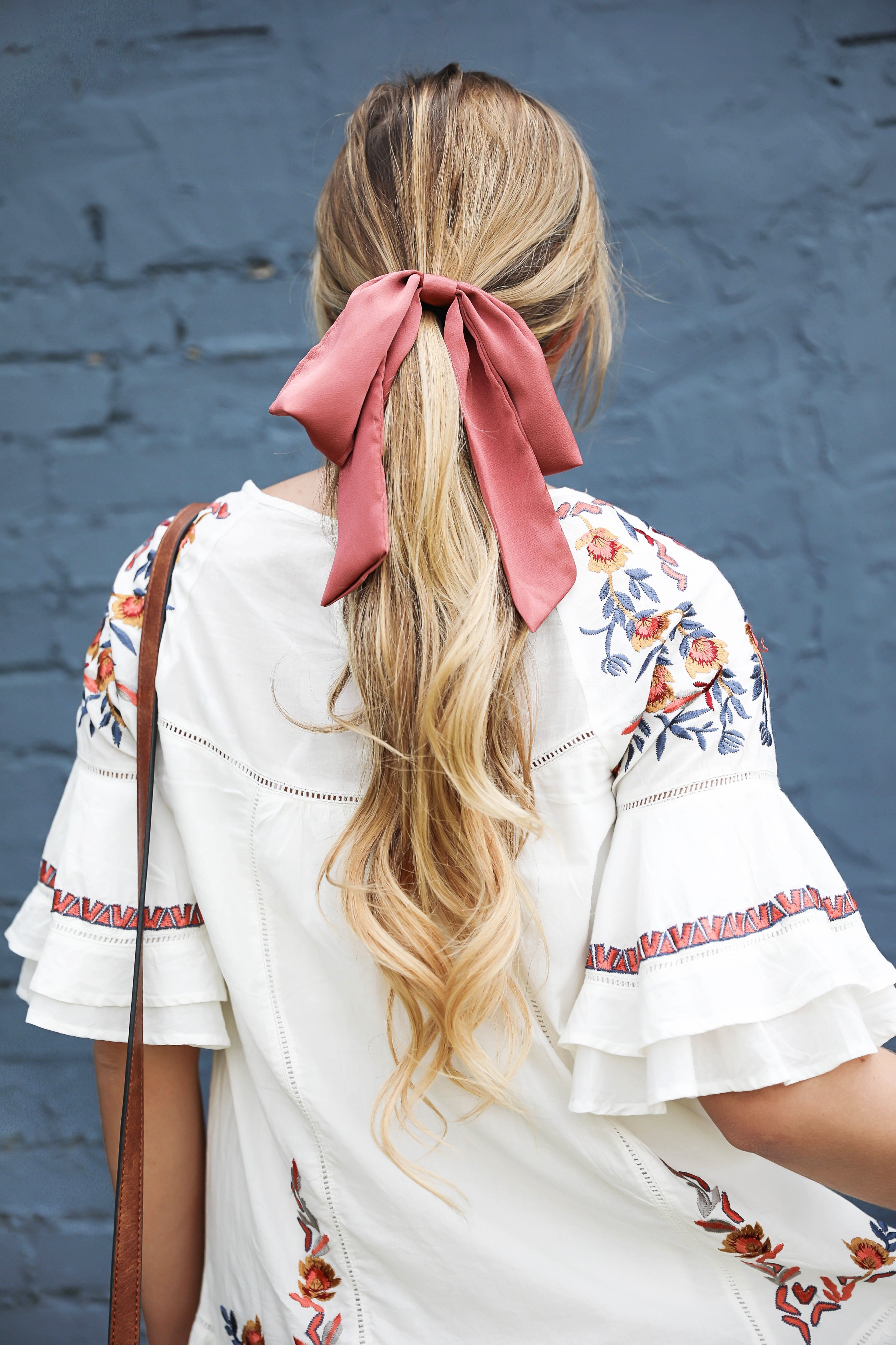 Free People embrodiered white dress for summer! I paired this adorable summer dress with a mauve hair bow and saddle bag by sole society! I love my hair in a ponytail with a bow, hair scarves are so in right now! Details on fashion blog by daily dose of charm by lauren lindmark