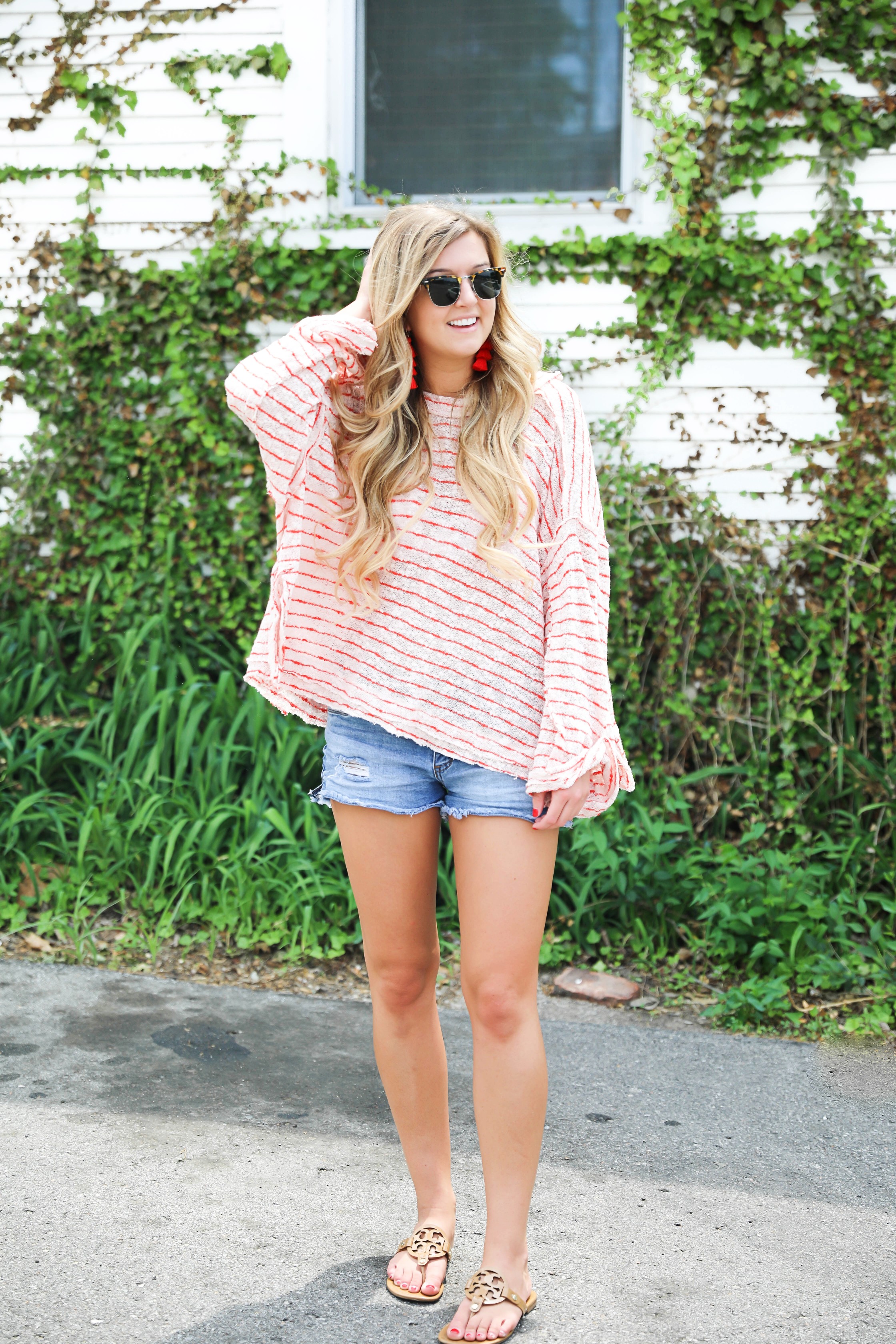 Striped red free people sweater with denim shorts and red tassel earrings! Perfect sweater for summer and days at the beach! Light weight summer sweater! Fourth of july outfit idea on fashion blog daily dose of charm by lauren lindmark